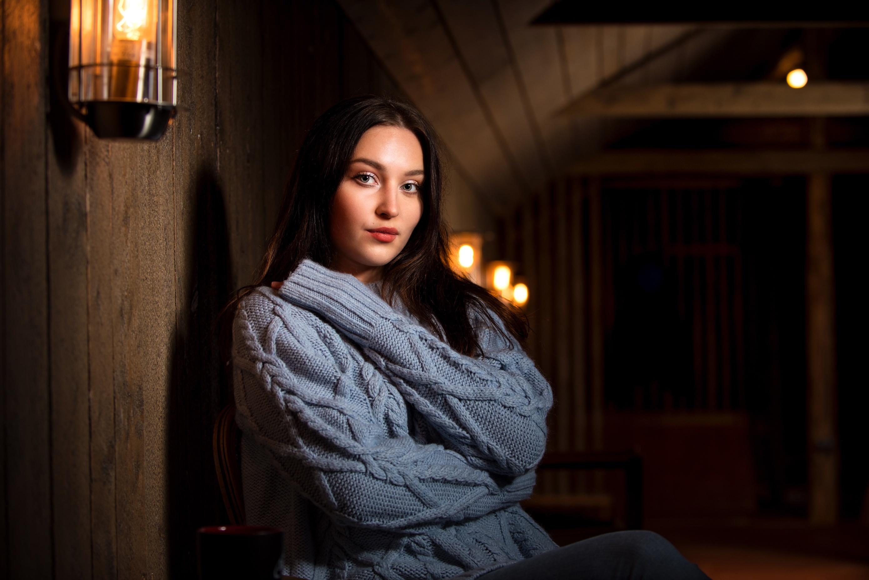 Brunette girl in a blue sweater sitting indoors HD Wallpaper