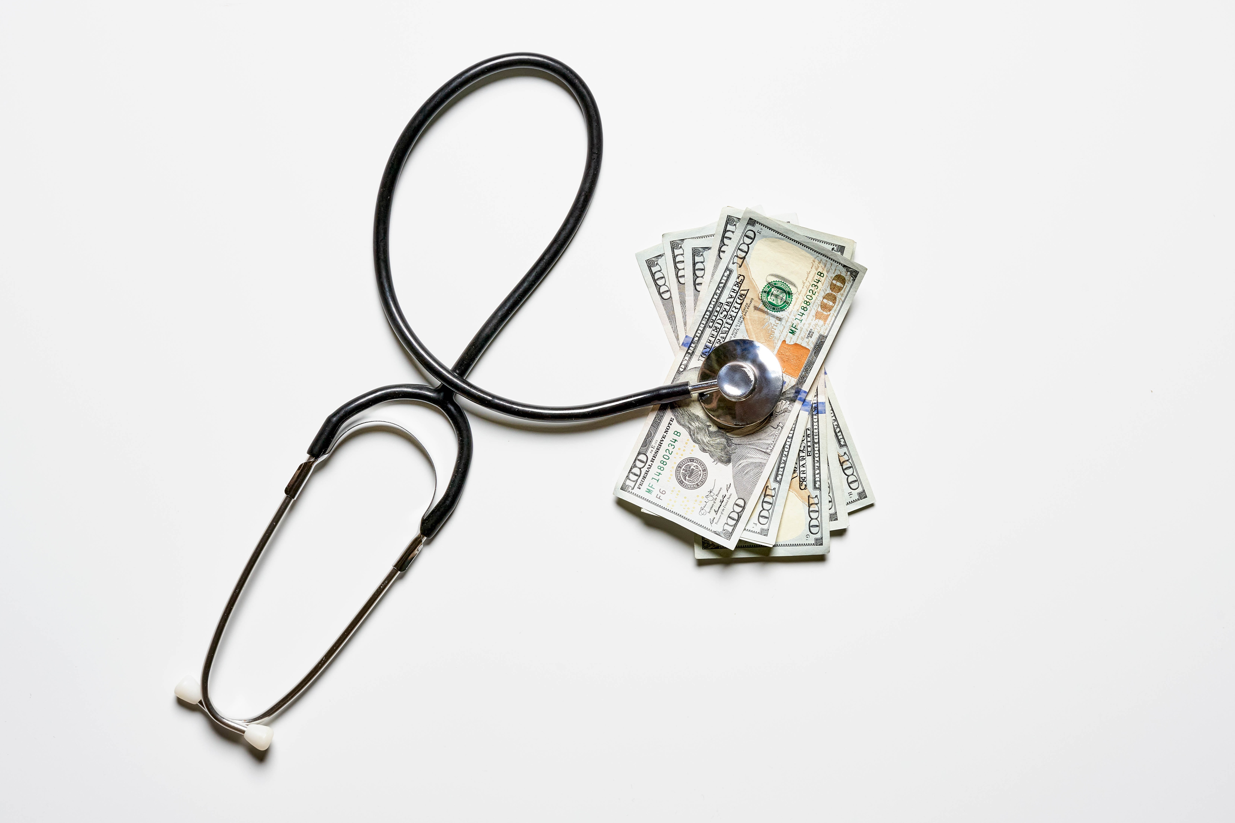 Stethoscope and US Dollar Bills on White Background HD Wallpaper