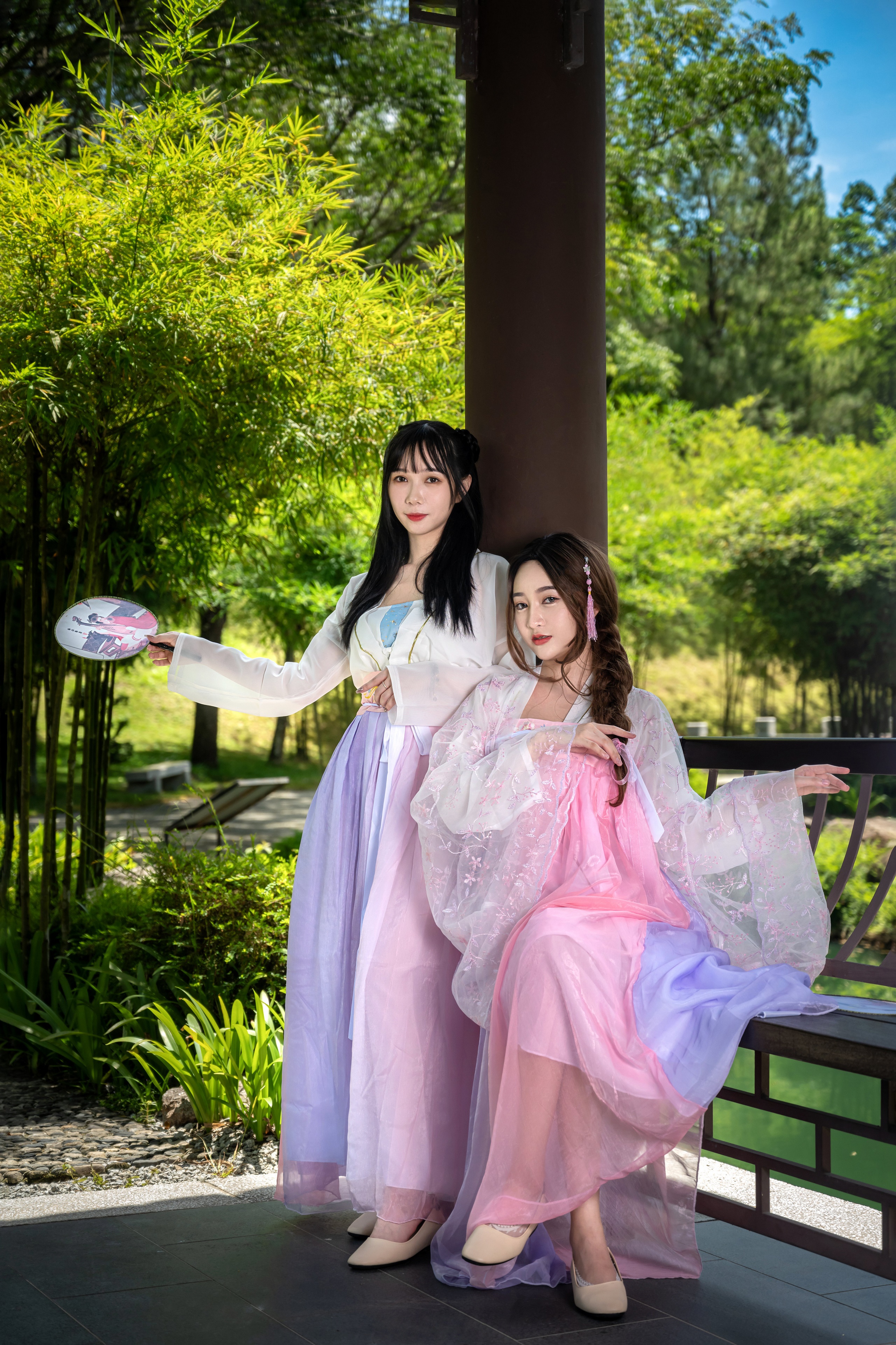Two Asian women in traditional dresses in a garden HD Phone Wallpaper