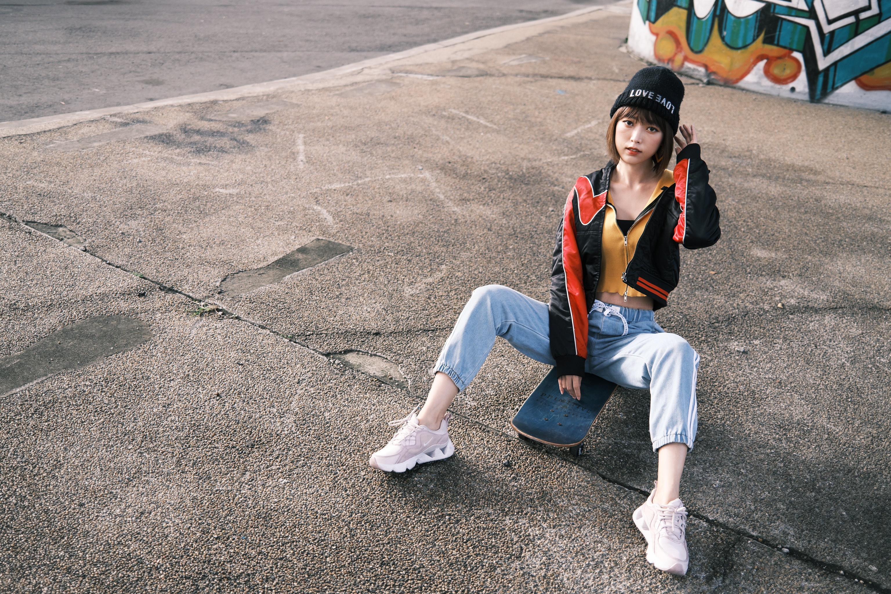 Asian woman in winter hat sitting on skateboard HD Wallpaper