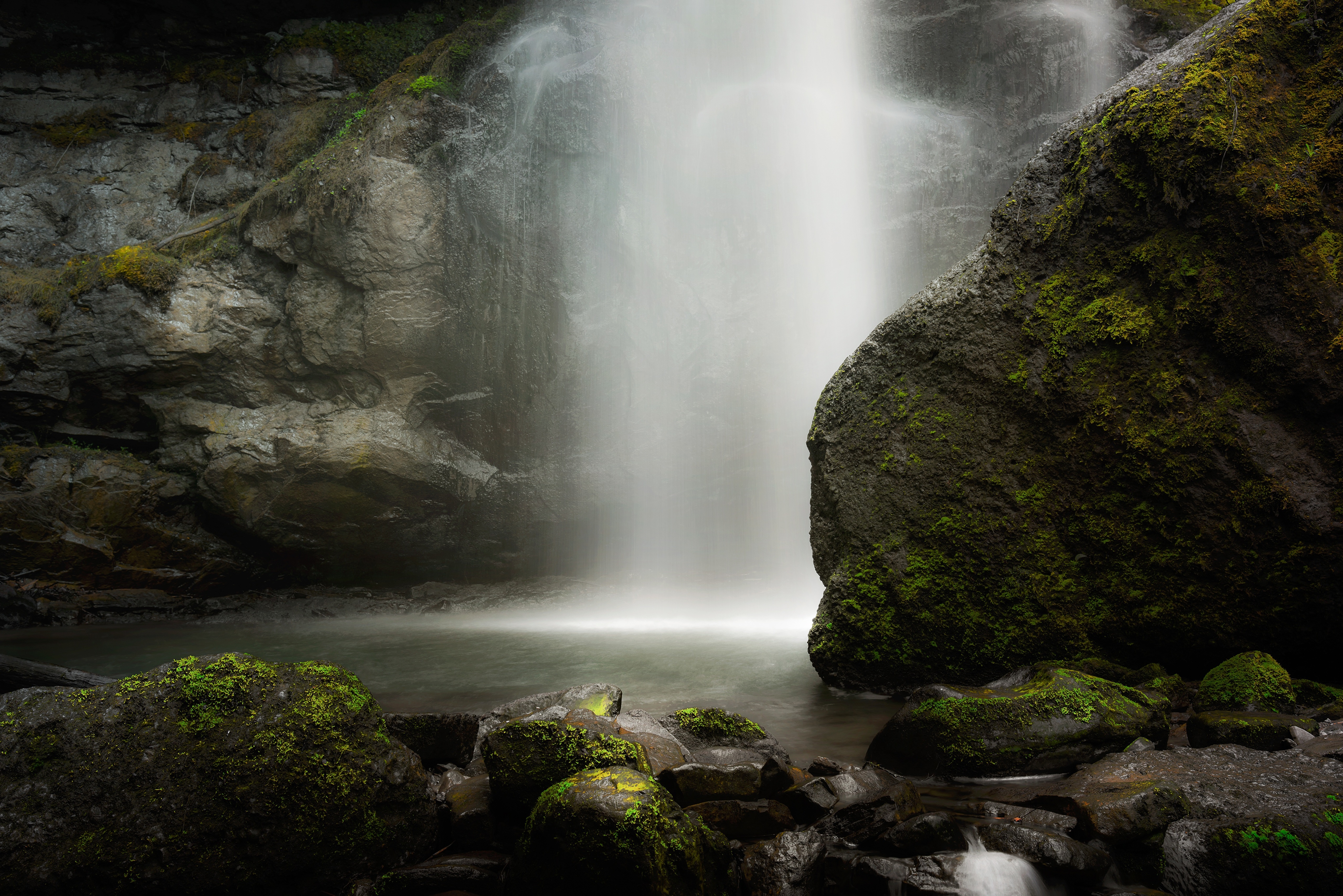Waterfall cascading over mossy rocks HD Wallpaper