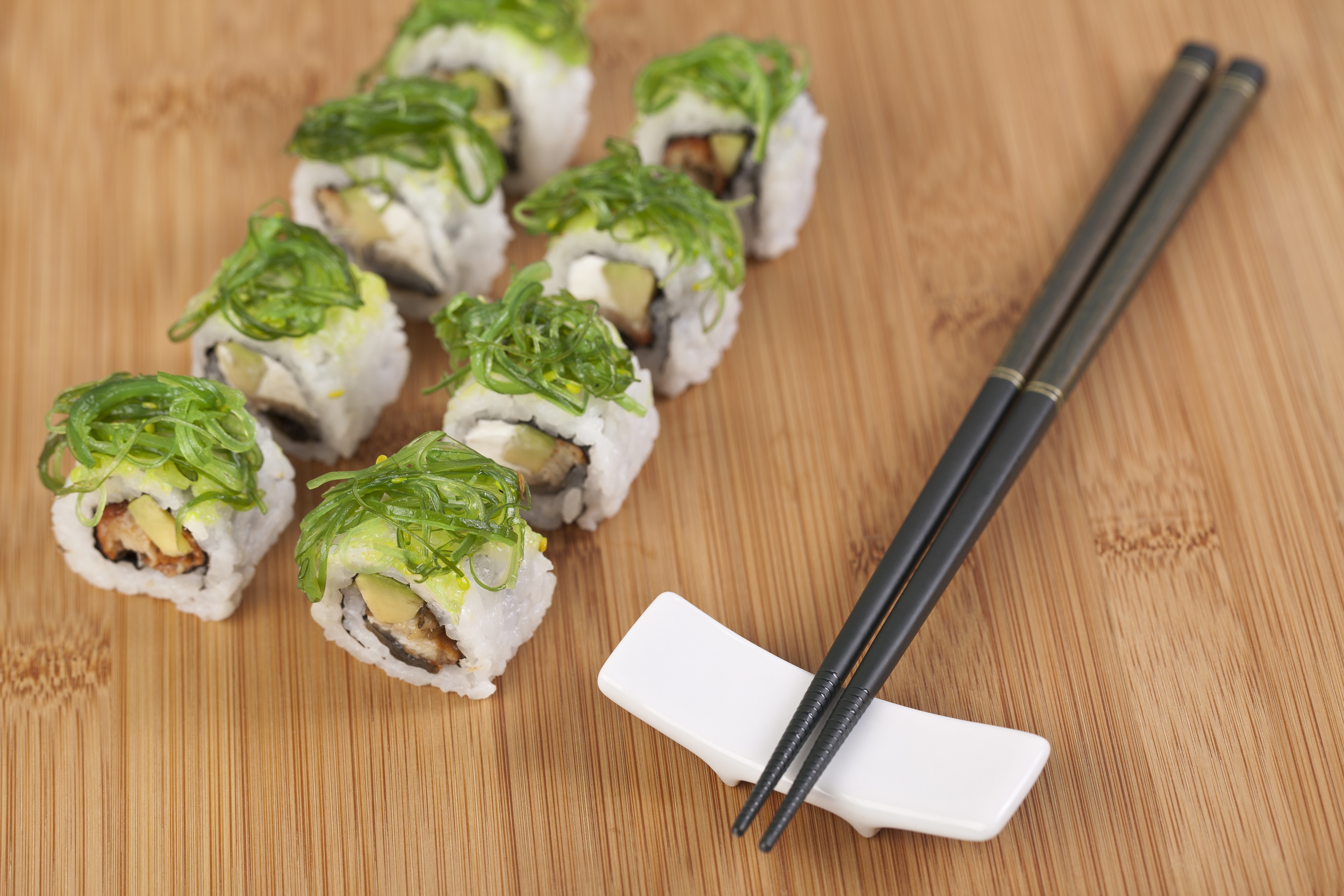 Sushi rolls with chopsticks on a wooden board HD Wallpaper