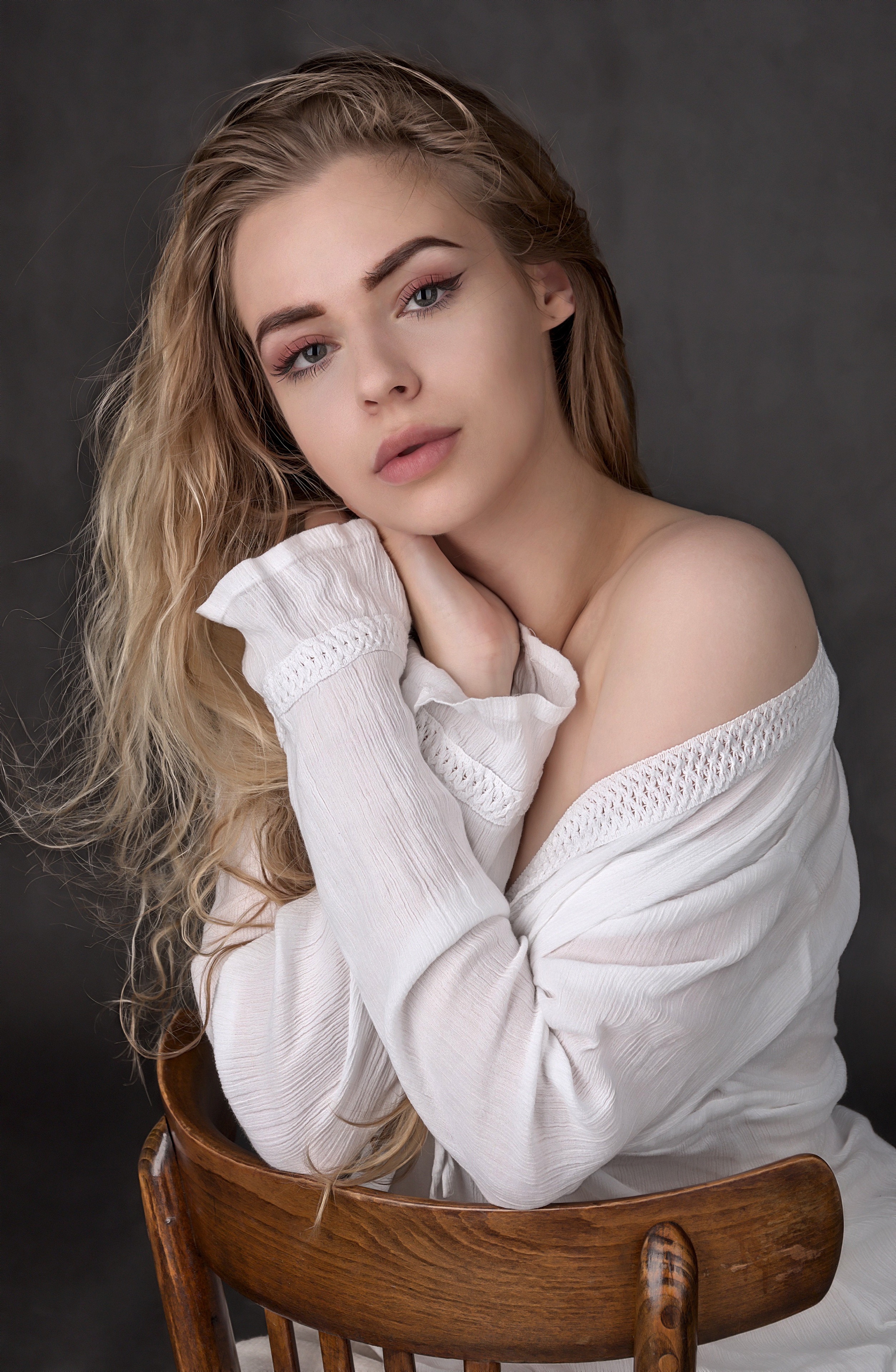 Blonde girl sitting on a wooden chair HD Phone Wallpaper