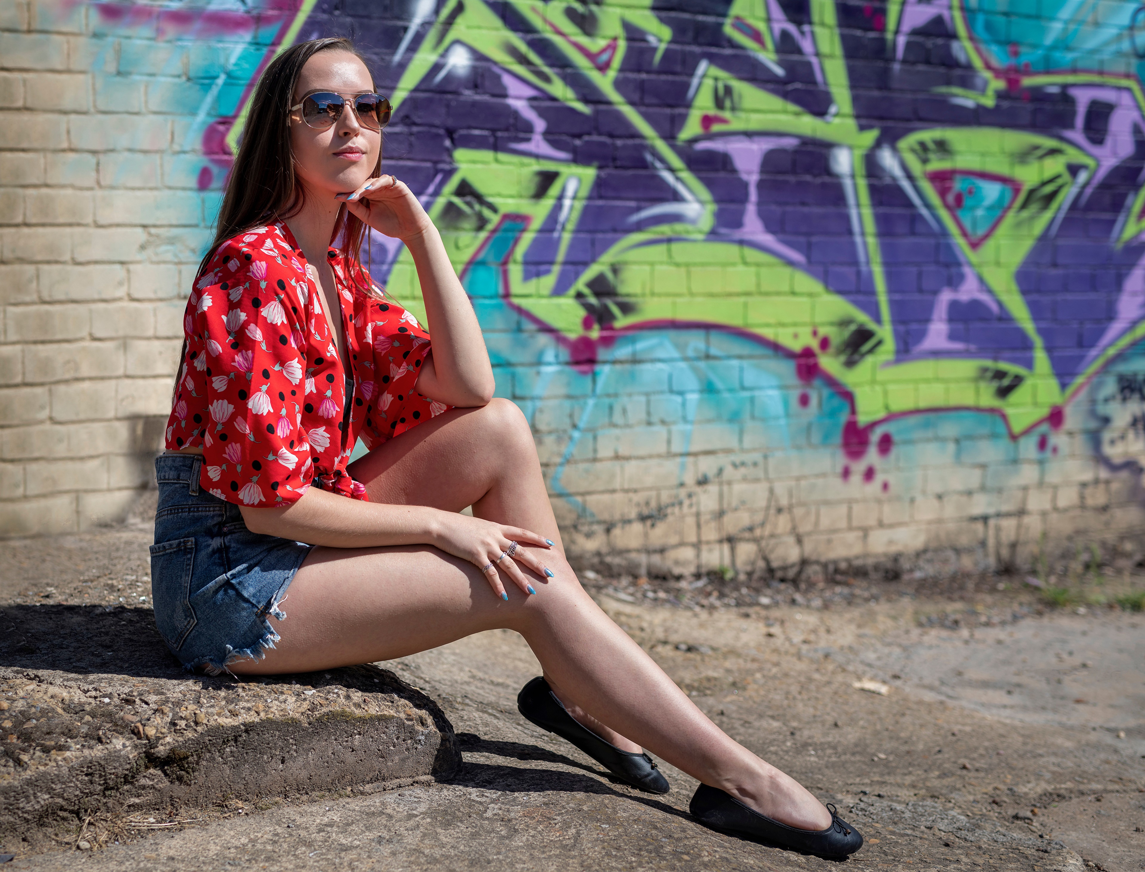 Model sitting by graffiti wall HD Wallpaper