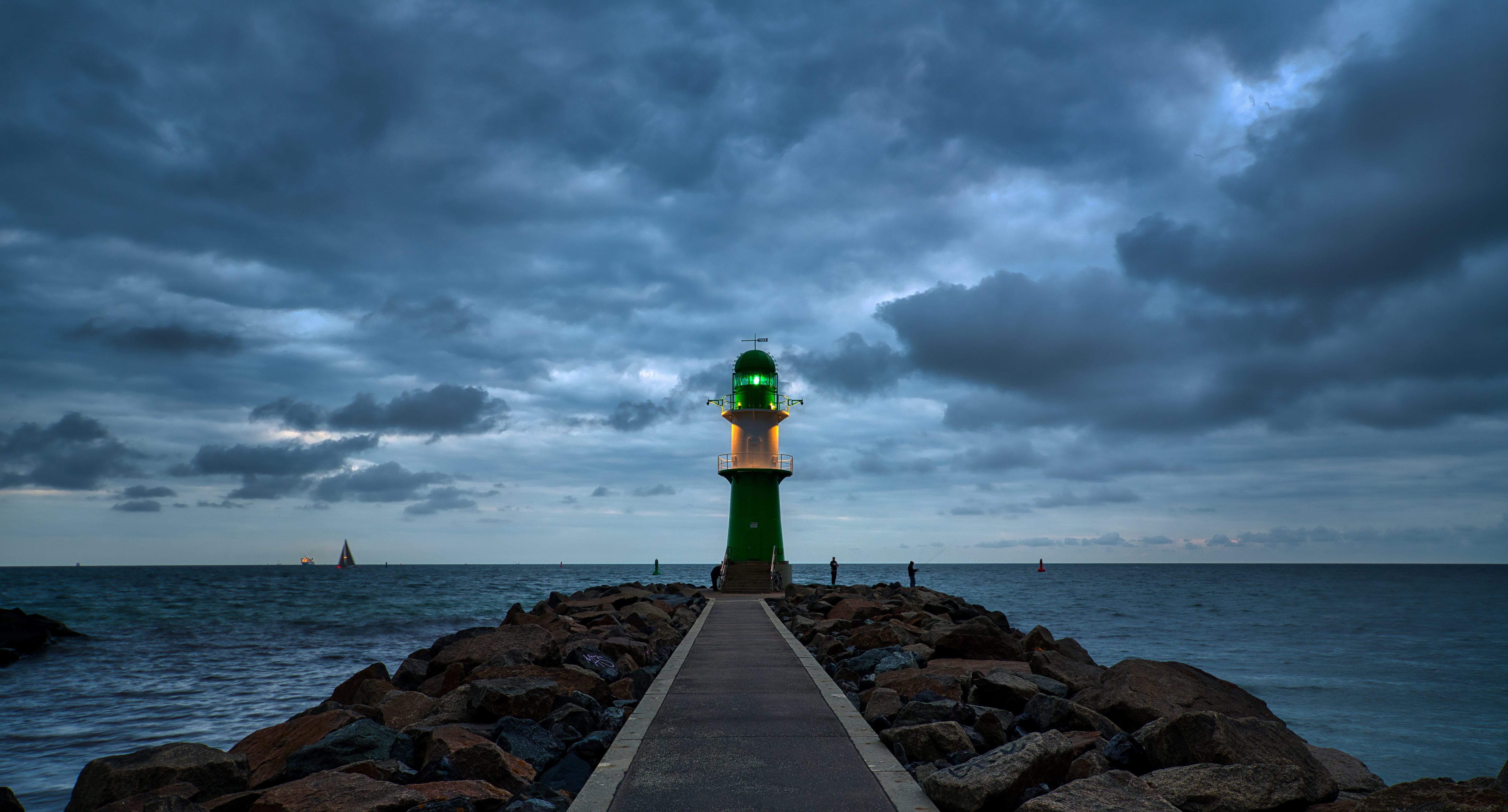 Lighthouse on a rocky pier at dusk, Germany HD Wallpaper