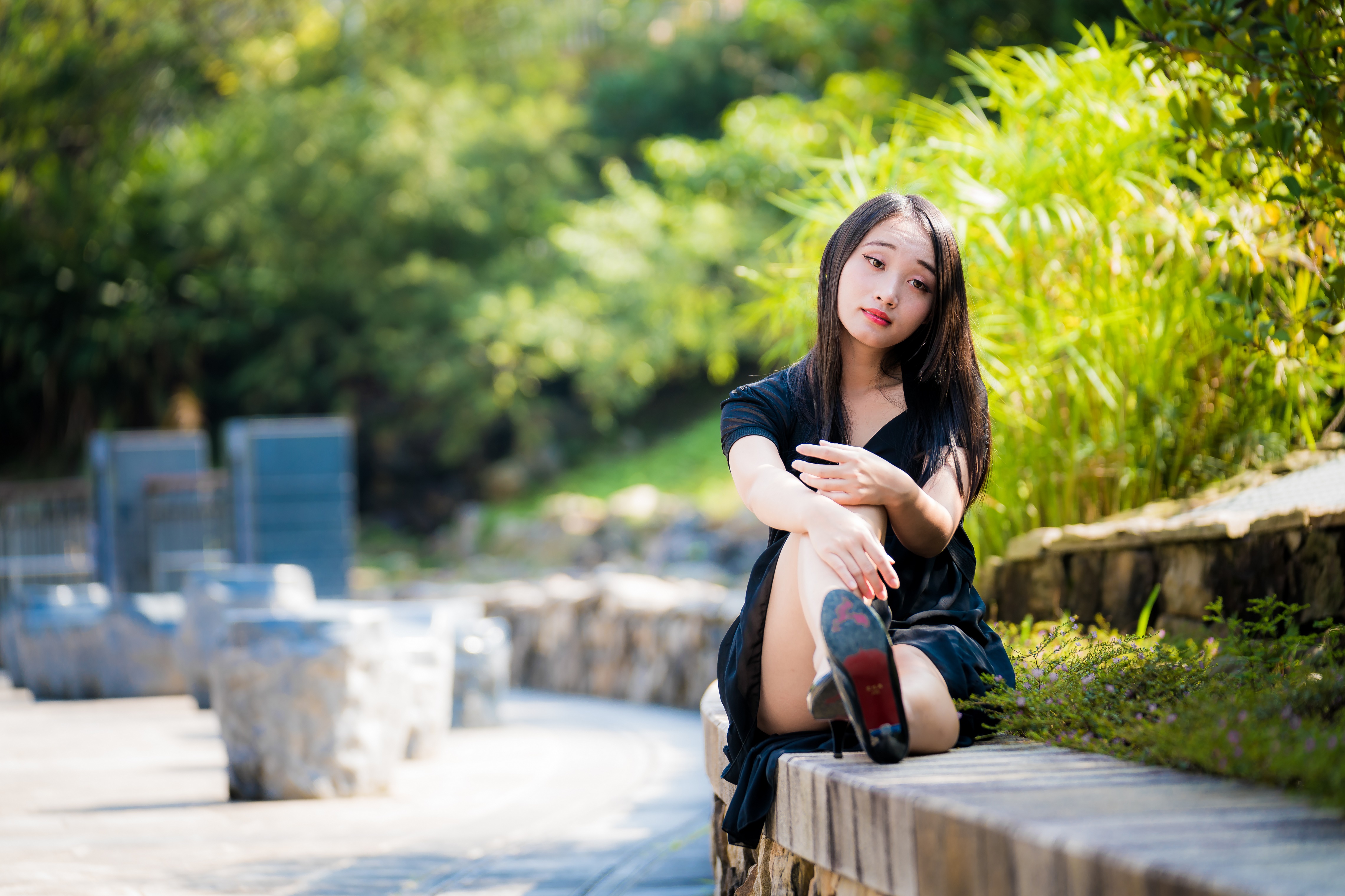 Asian woman sitting on a stone wall HD Wallpaper