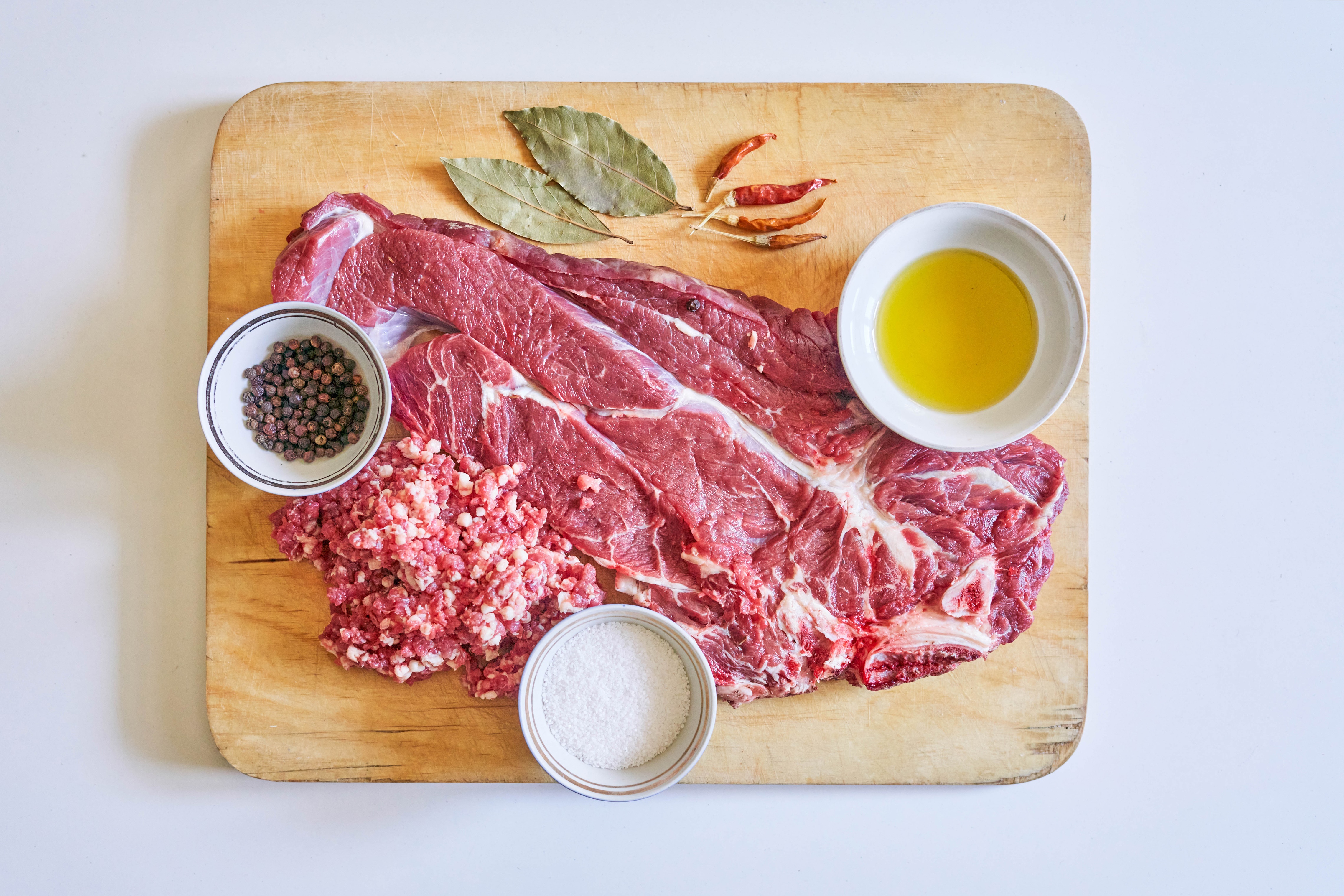 Raw meat, spices, and oil on a cutting board HD Wallpaper