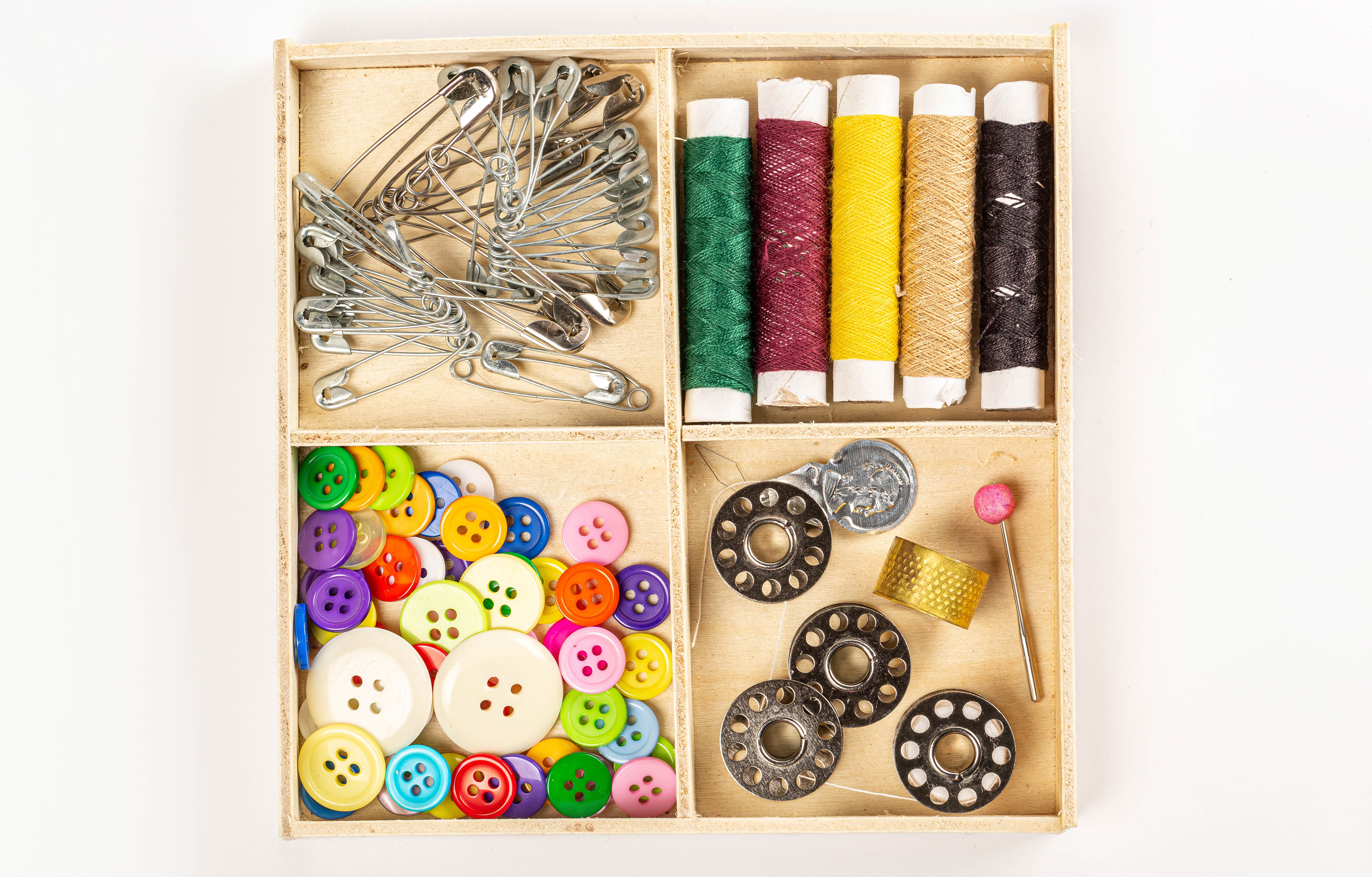 Sewing kit with threads, buttons, safety pins, and bobbins HD Wallpaper