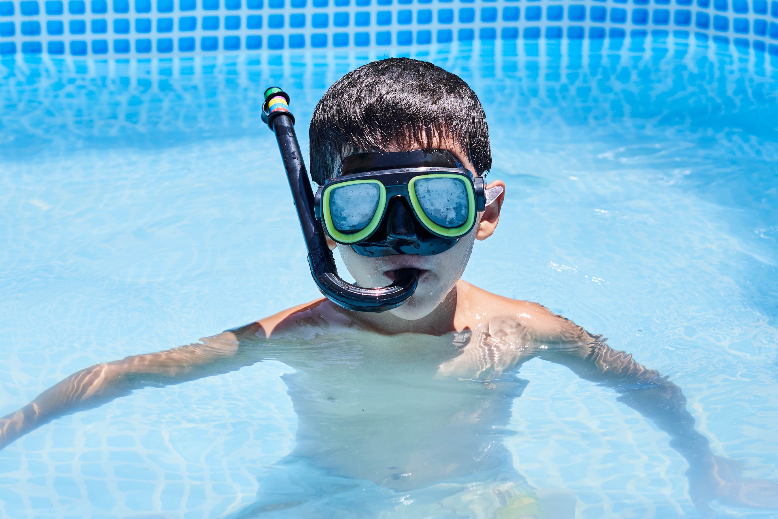 Boy in swimming pool wearing snorkel mask HD Wallpaper