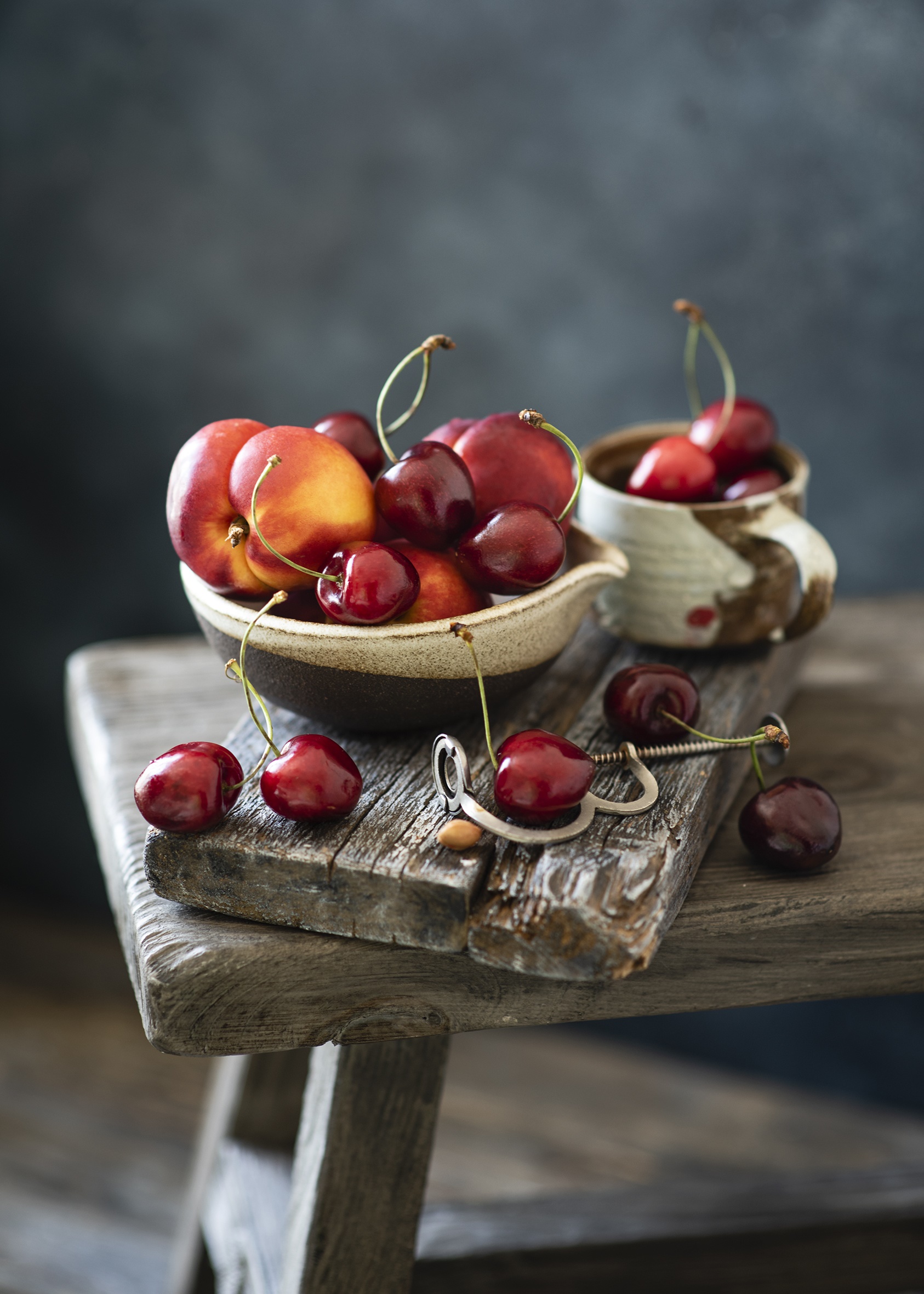 Cherries and peaches in bowls on wooden planks HD Phone Wallpaper