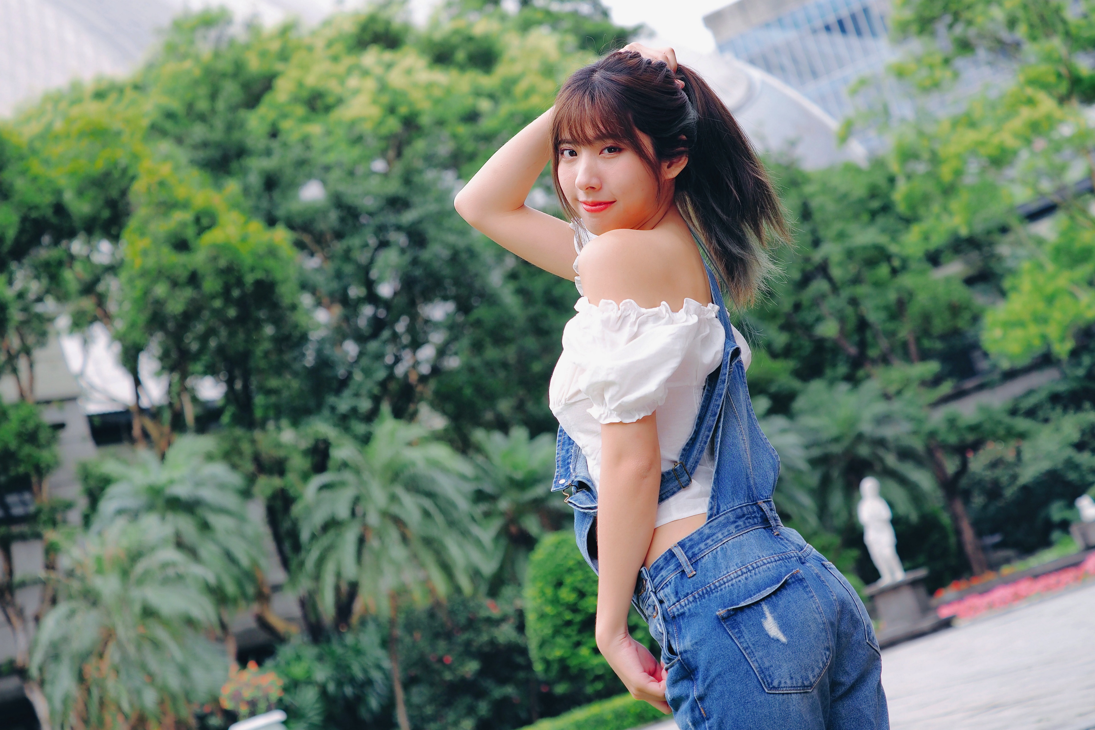 Asian woman in denim overalls posing outdoors HD Wallpaper