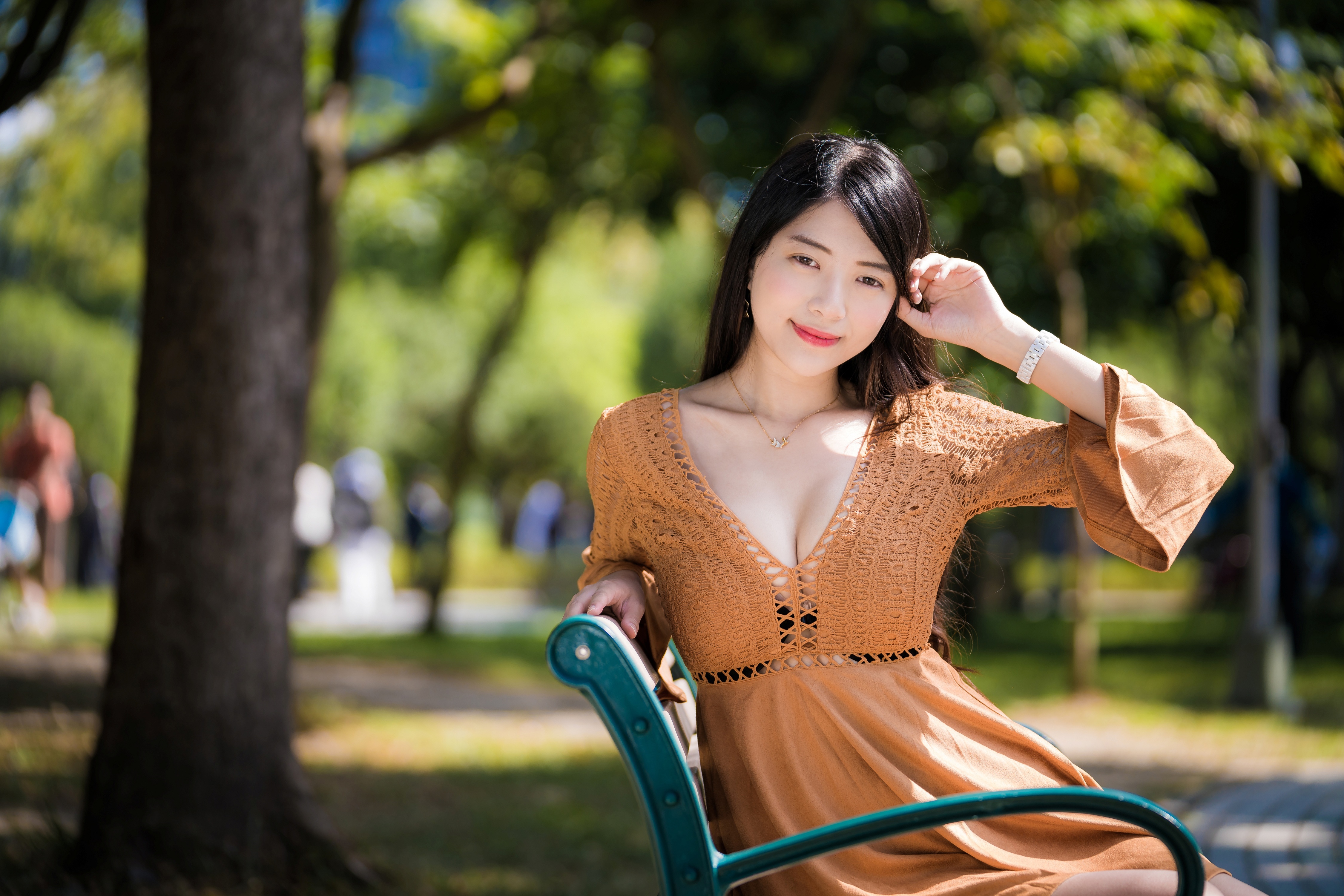 Asian woman in brown dress sitting on a park bench HD Wallpaper