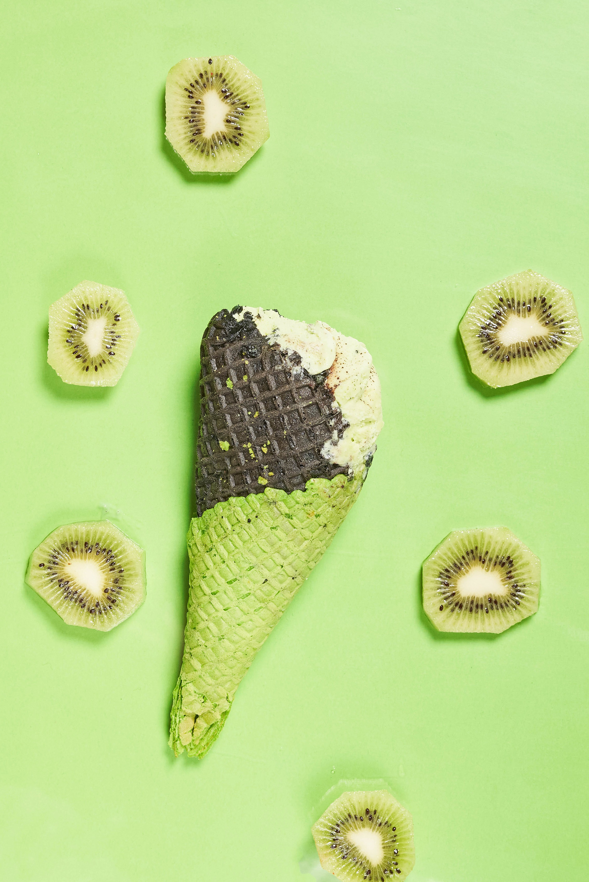 Ice cream cone with kiwi slices on a green background HD Phone Wallpaper