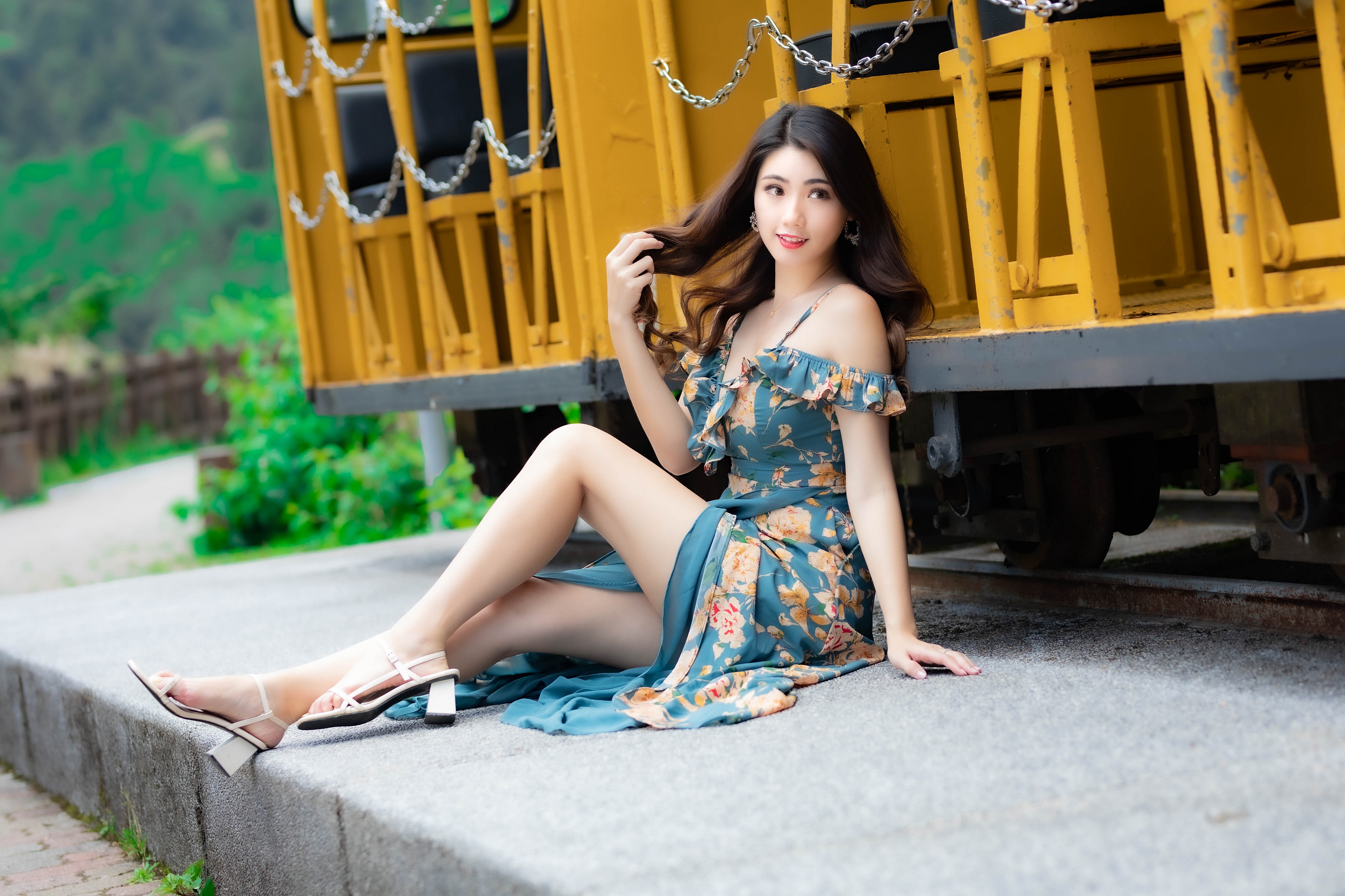 Asian woman in floral dress sitting by a train HD Wallpaper