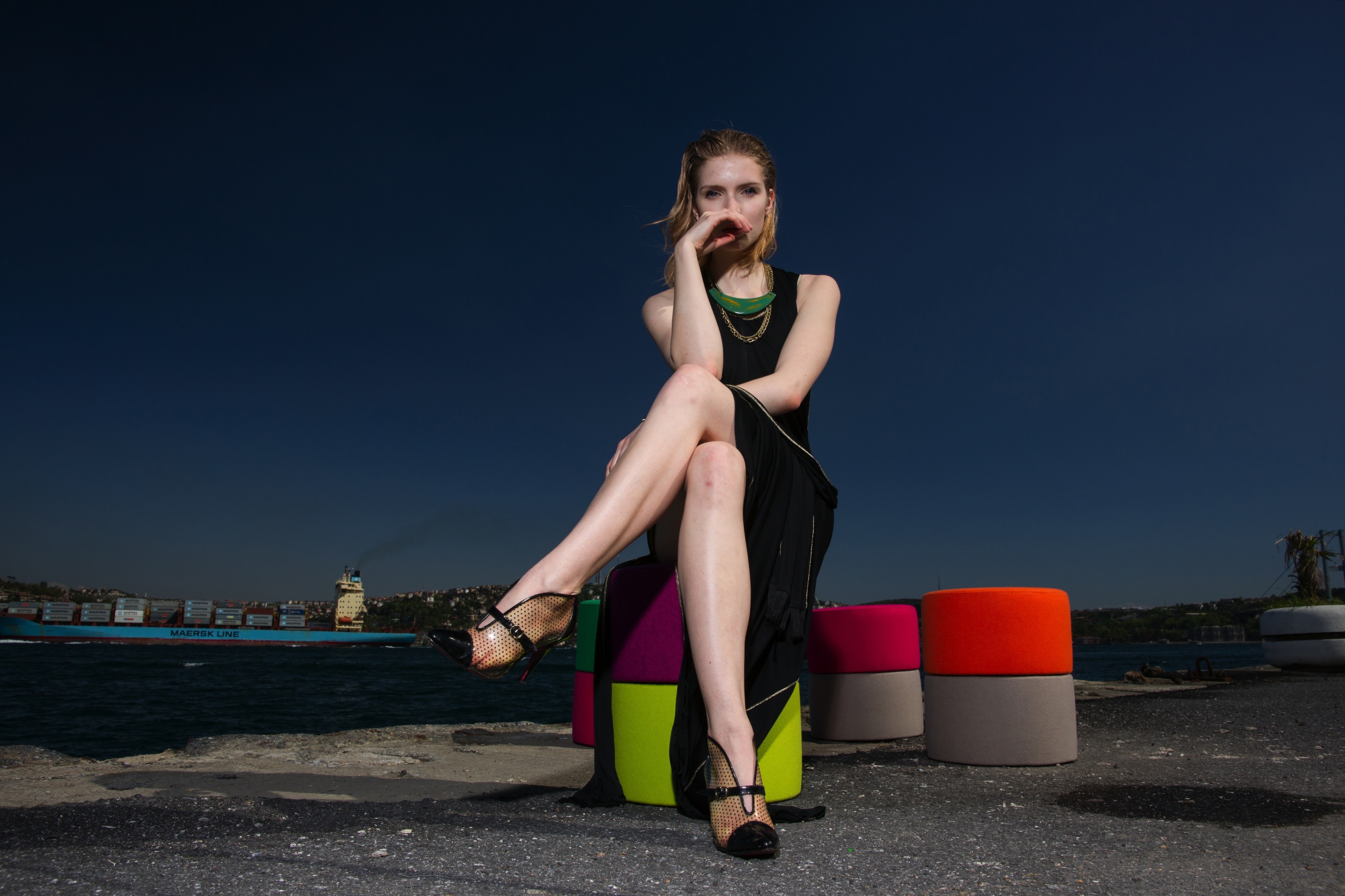 Woman in black dress sitting on colorful stools HD Wallpaper