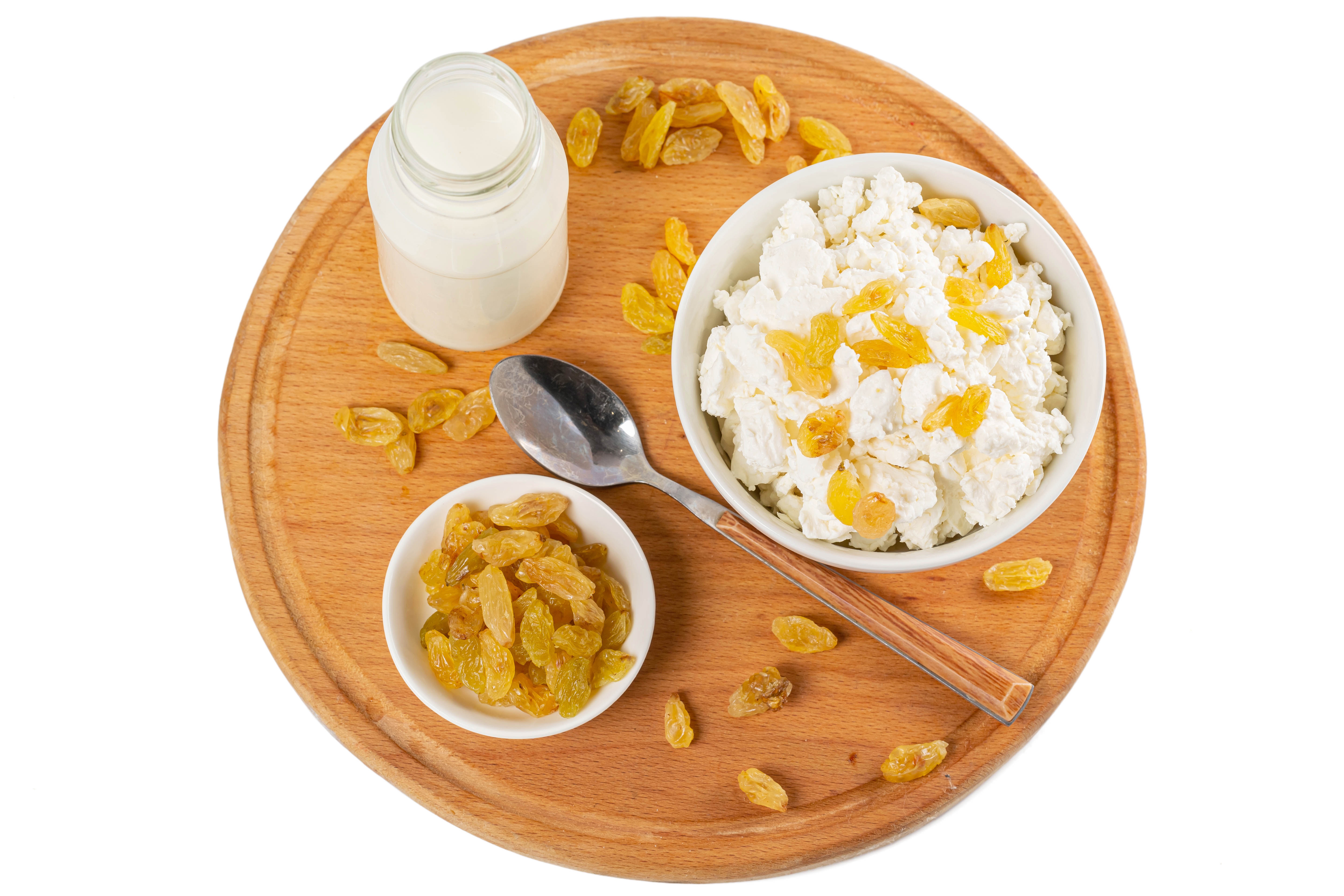Cottage cheese with raisins and milk on a cutting board HD Wallpaper