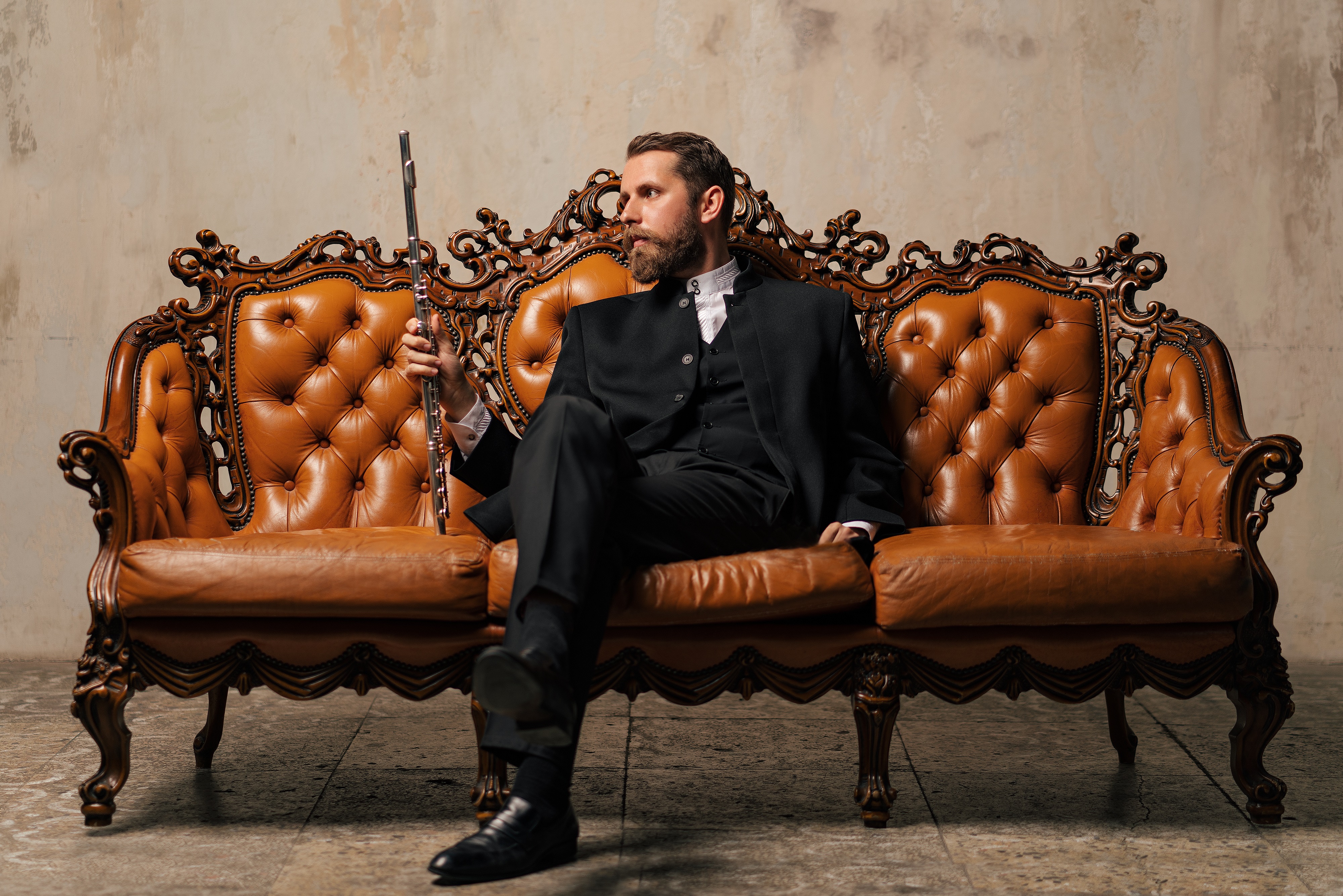 Yaroslav Kotov in a suit with a flute on a sofa HD Wallpaper