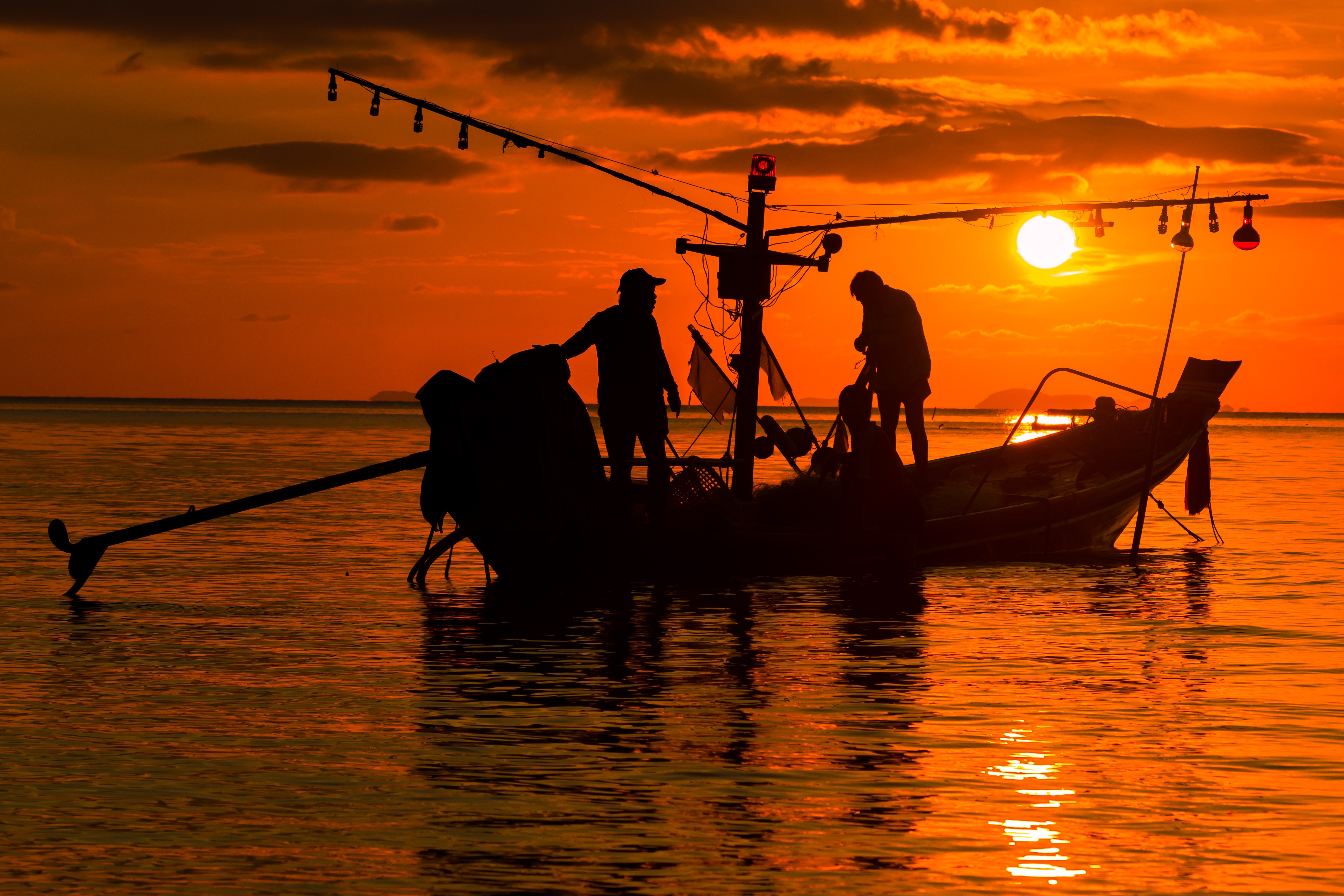 Fishing boat with fishermen at sunset HD Wallpaper