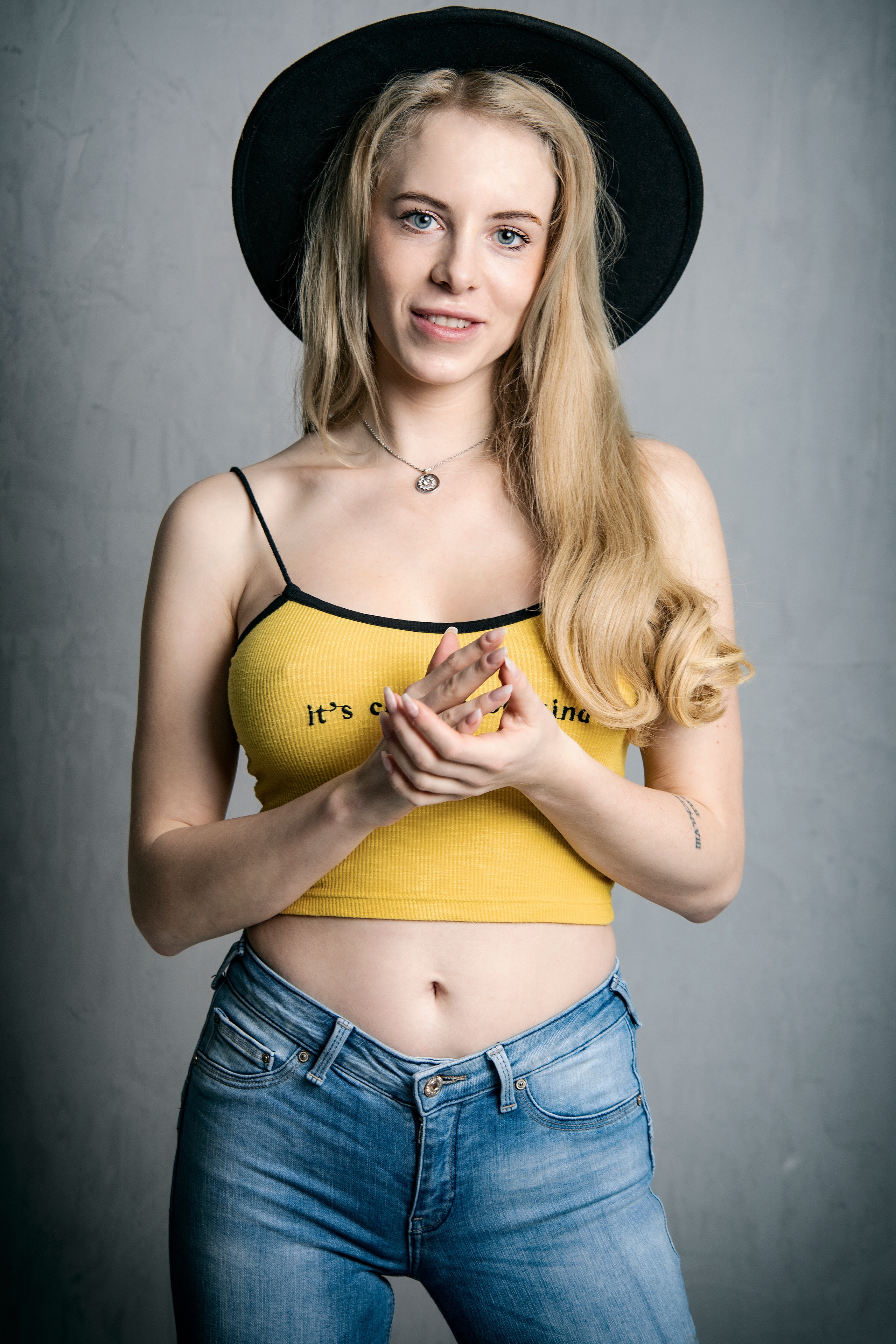 Blonde girl wearing a hat, singlet, and jeans HD Phone Wallpaper