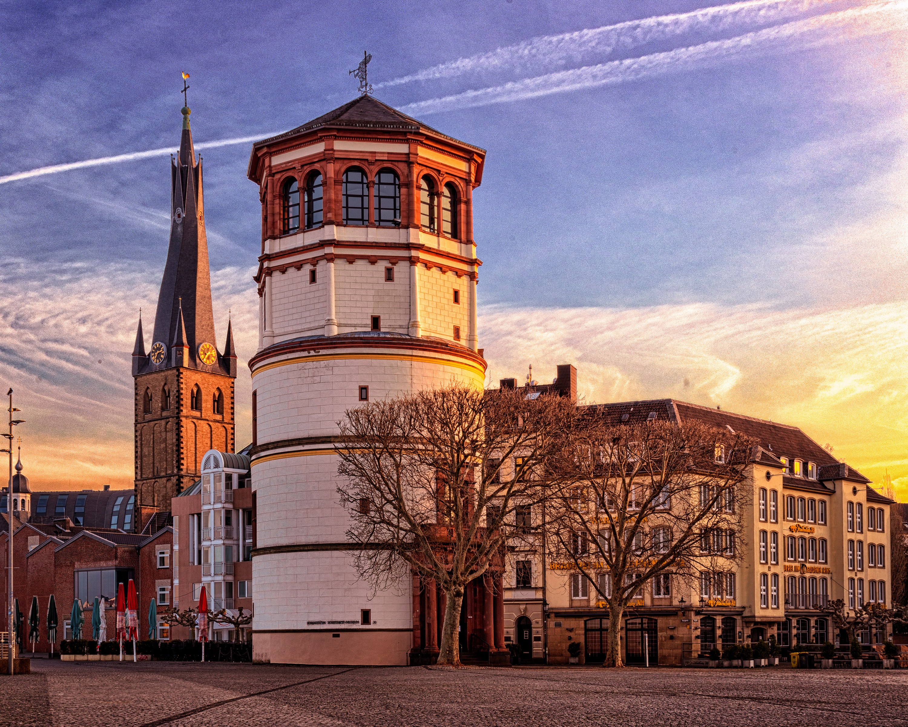 Old buildings and church tower in a town square at sunset HD Wallpaper