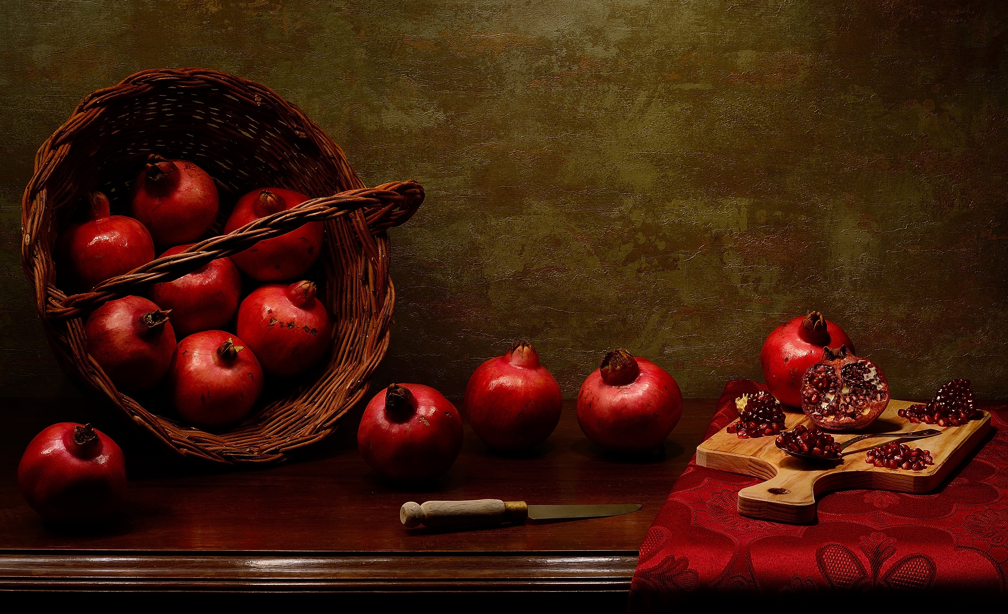 Still-life with pomegranates in a basket and on a cutting board HD Wallpaper