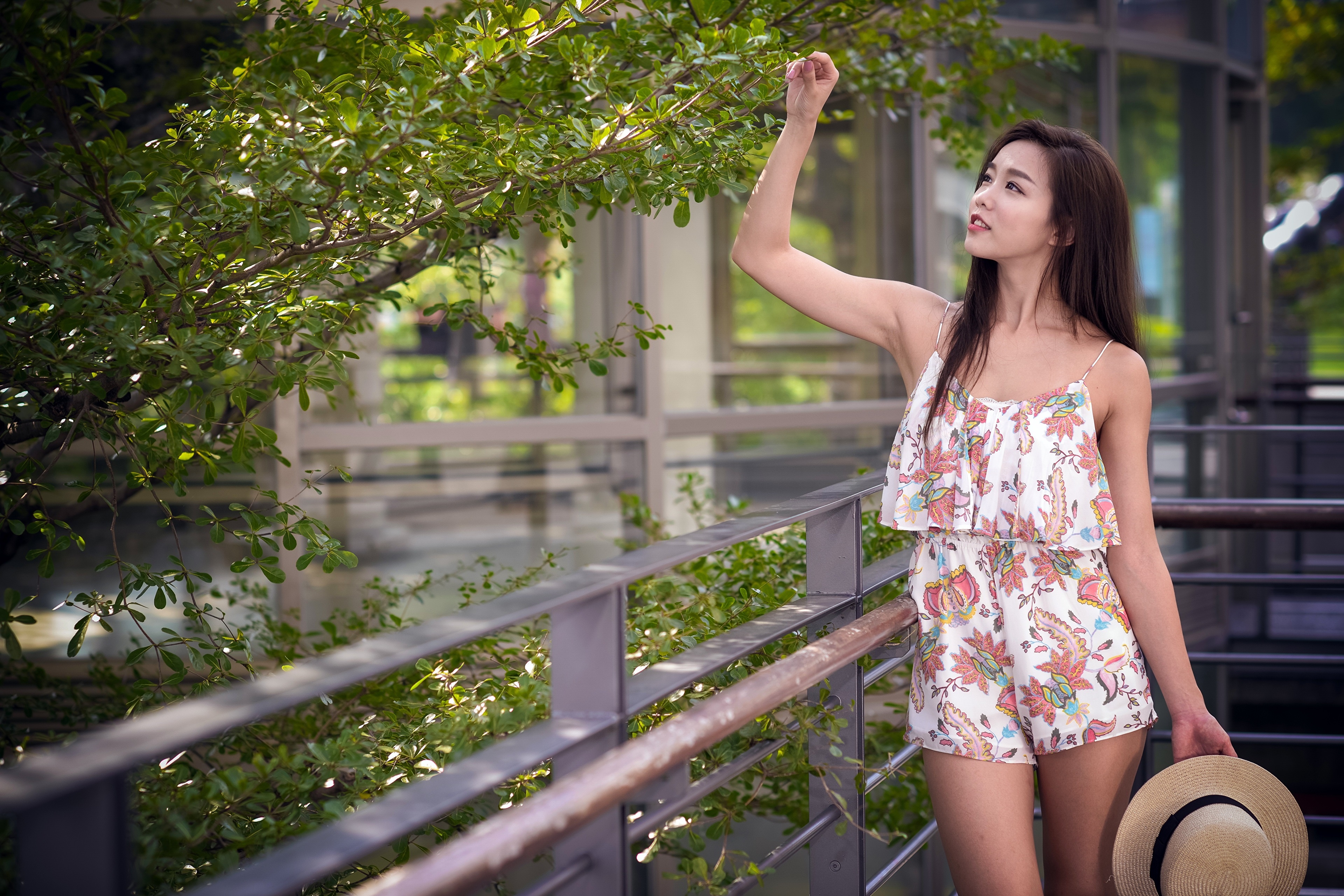 Asian woman in floral romper holding a hat HD Wallpaper
