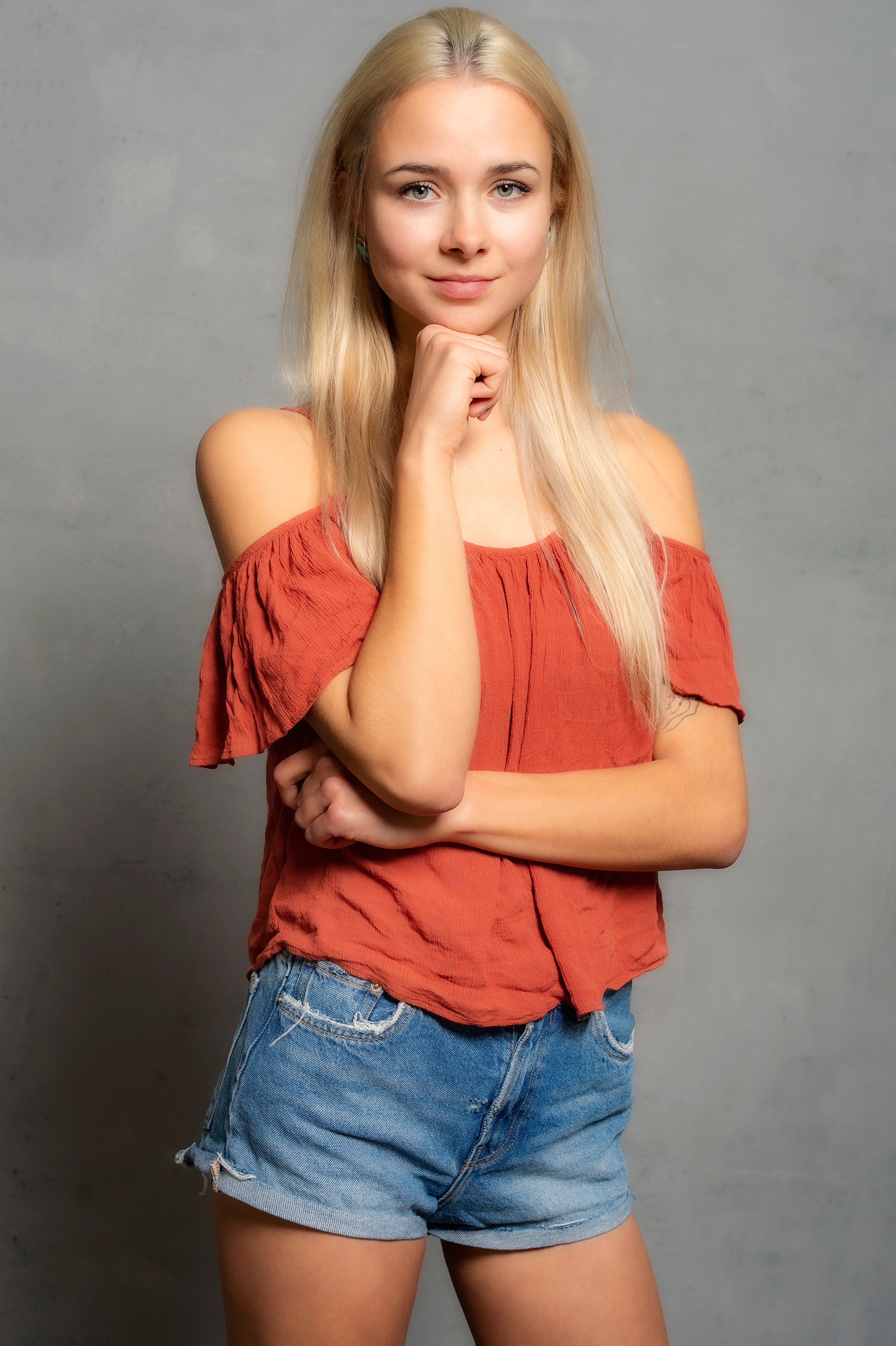 Blonde girl in shorts and blouse posing HD Phone Wallpaper