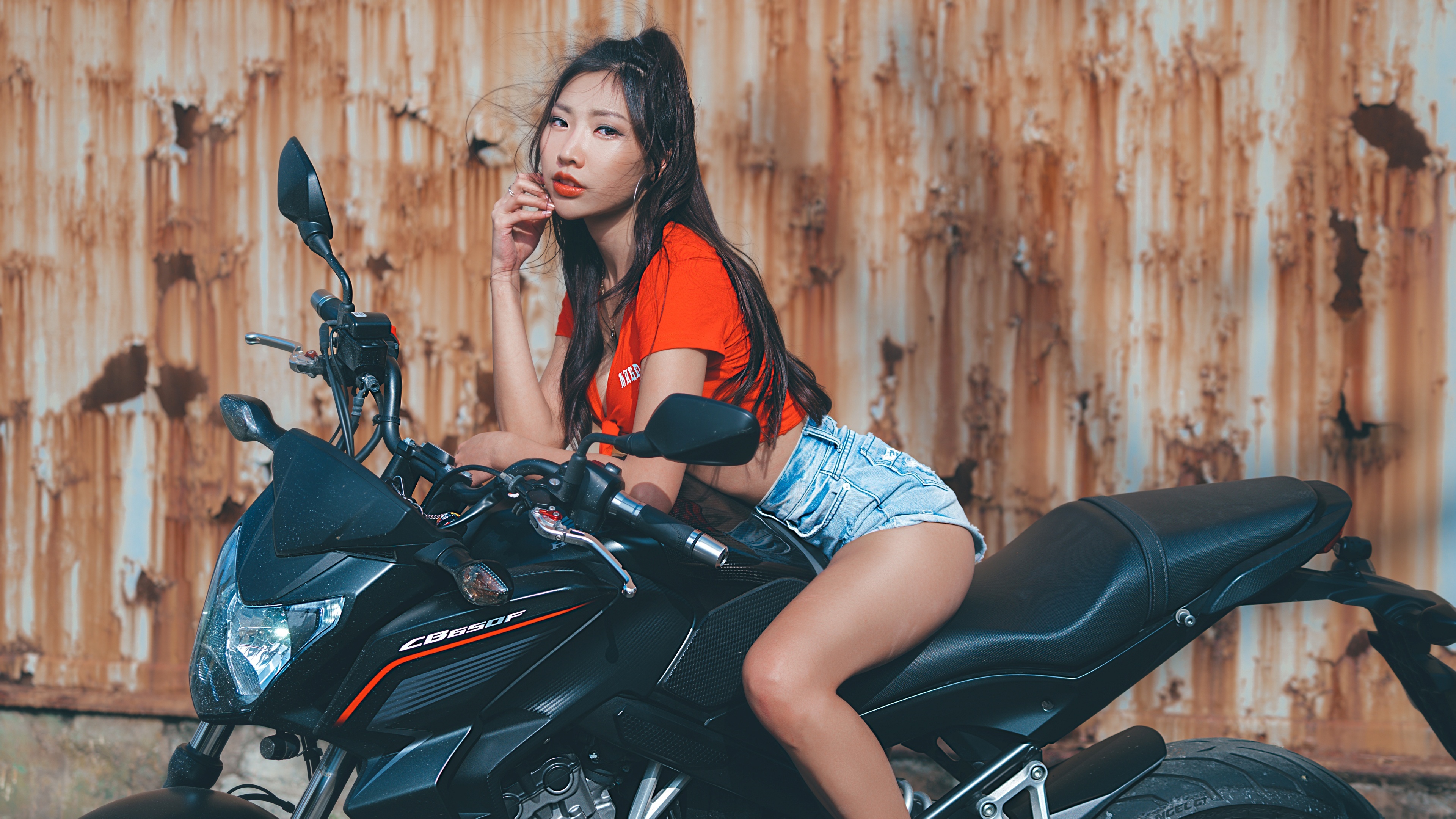 Brunette girl sitting on a Honda Cb450f motorcycle HD Wallpaper