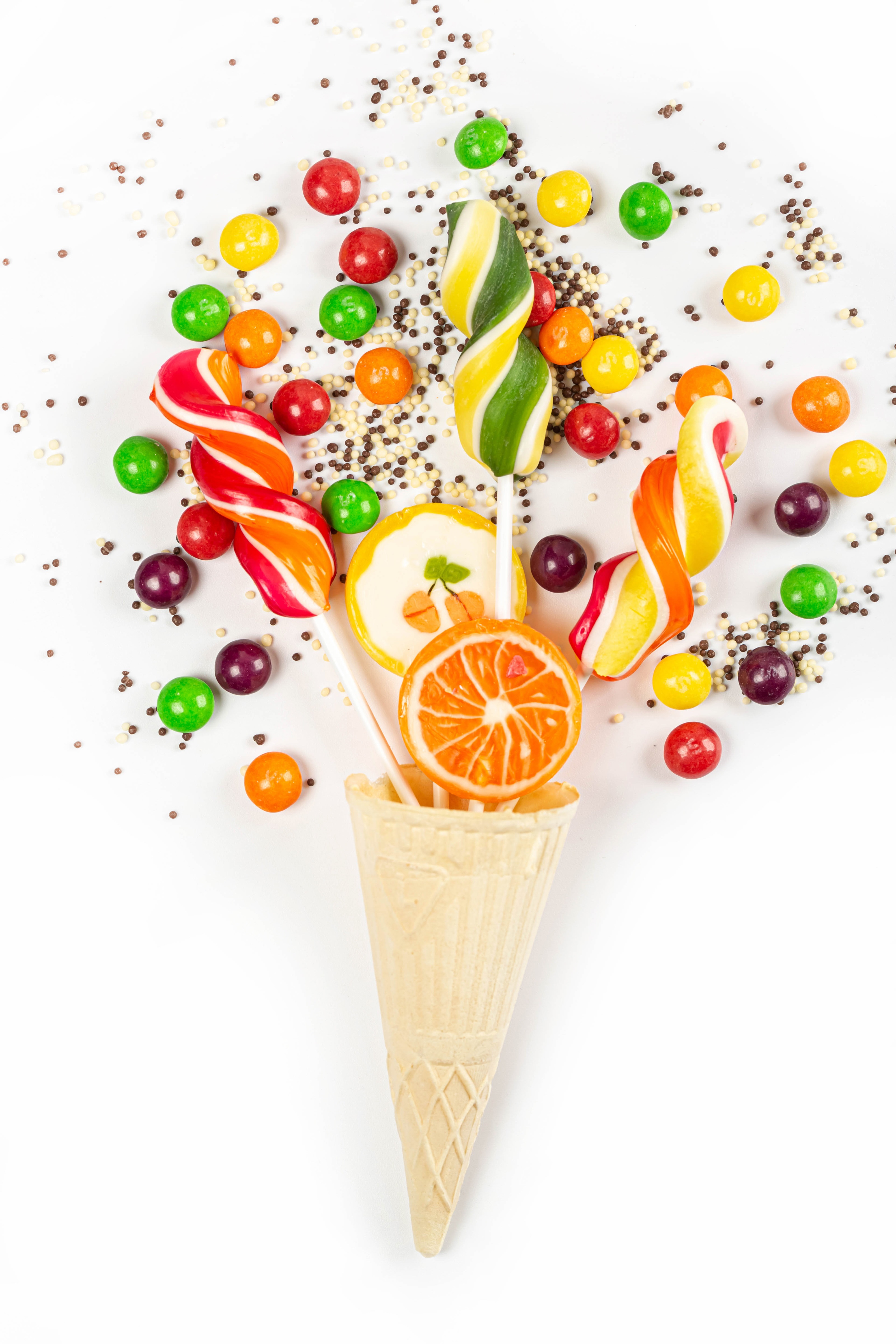 Ice cream cone filled with colorful lollipops and candies HD Phone Wallpaper