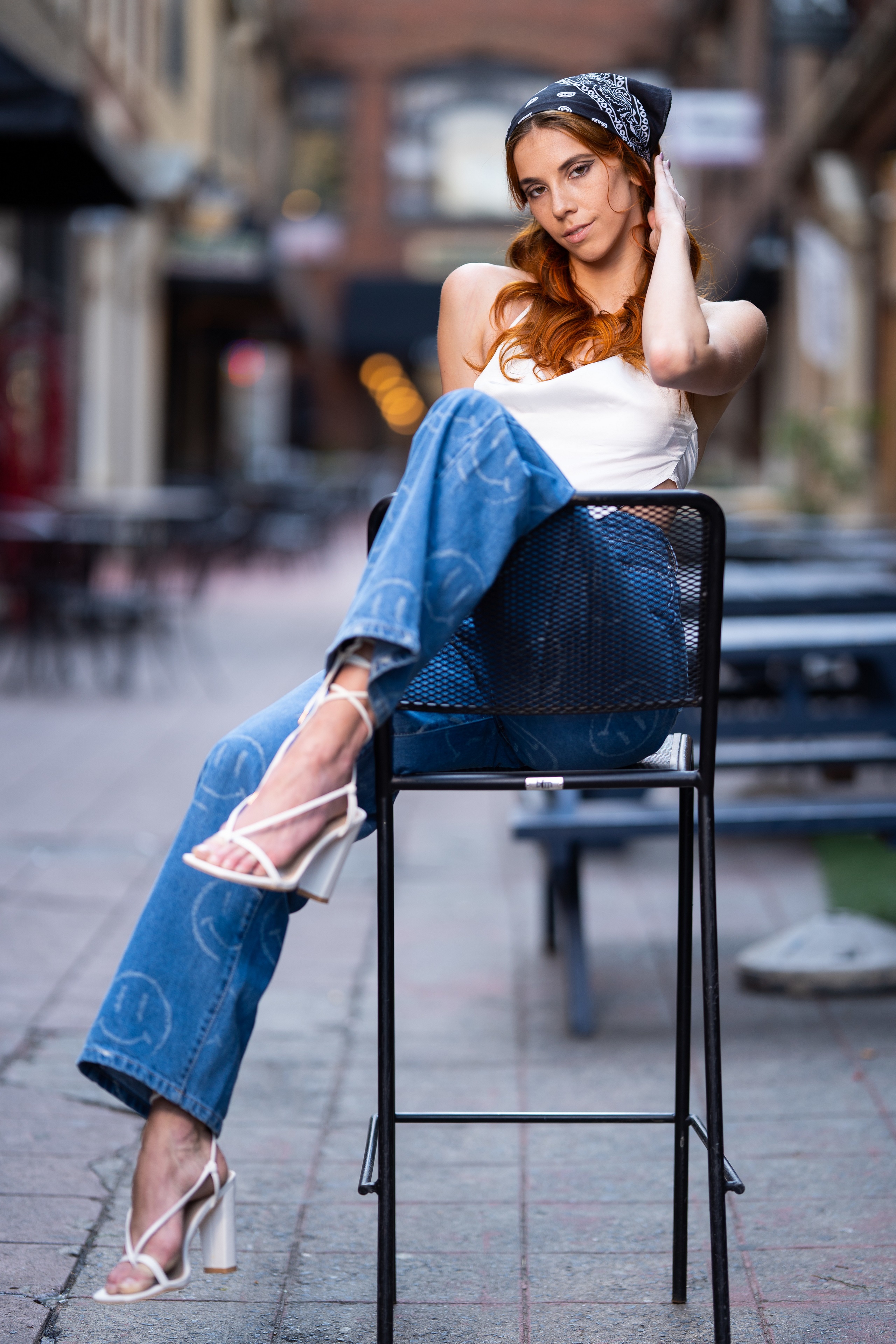 Redhead girl in jeans and singlet posing on a chair HD Phone Wallpaper
