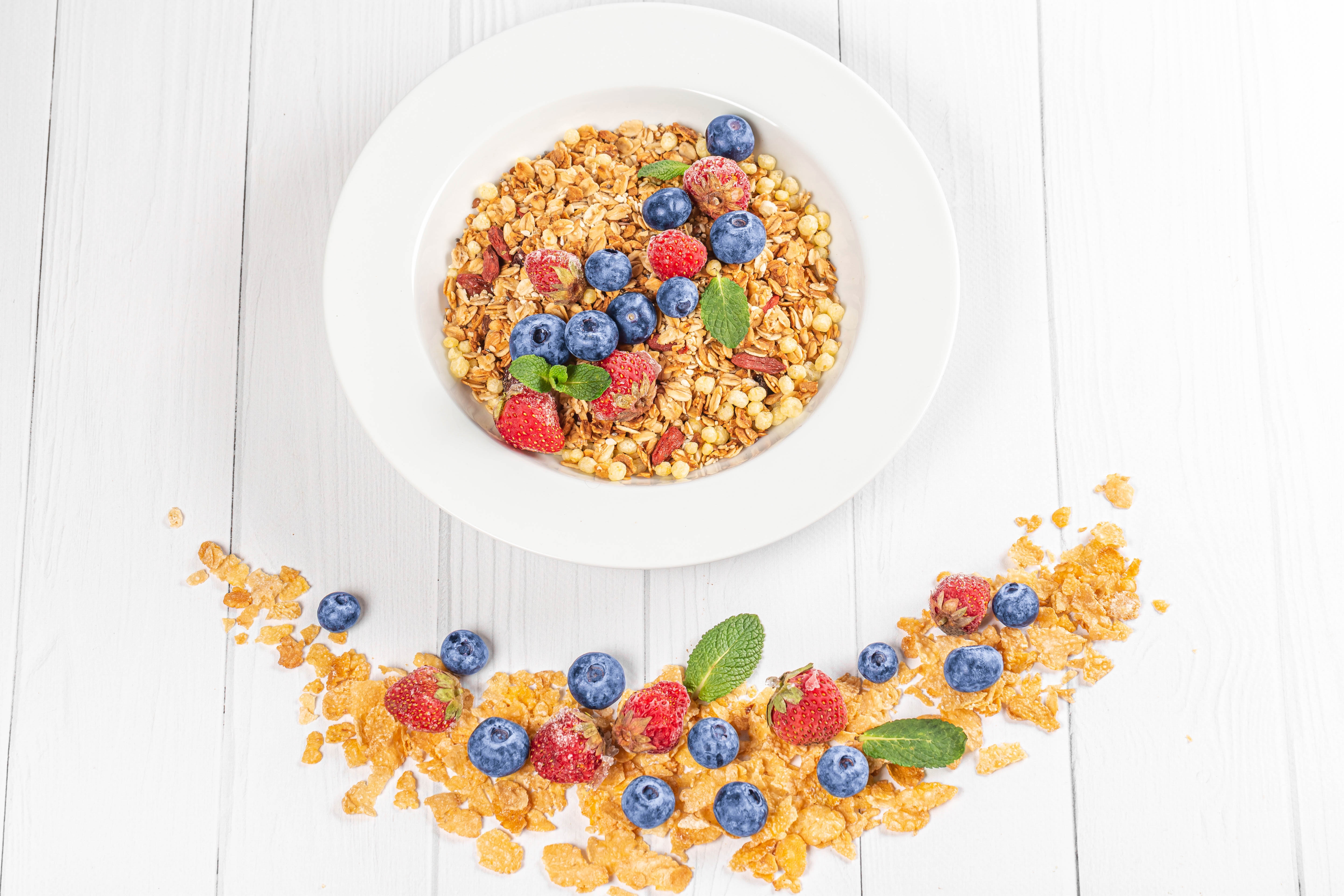 Granola with blueberries and strawberries on a white plate HD Wallpaper