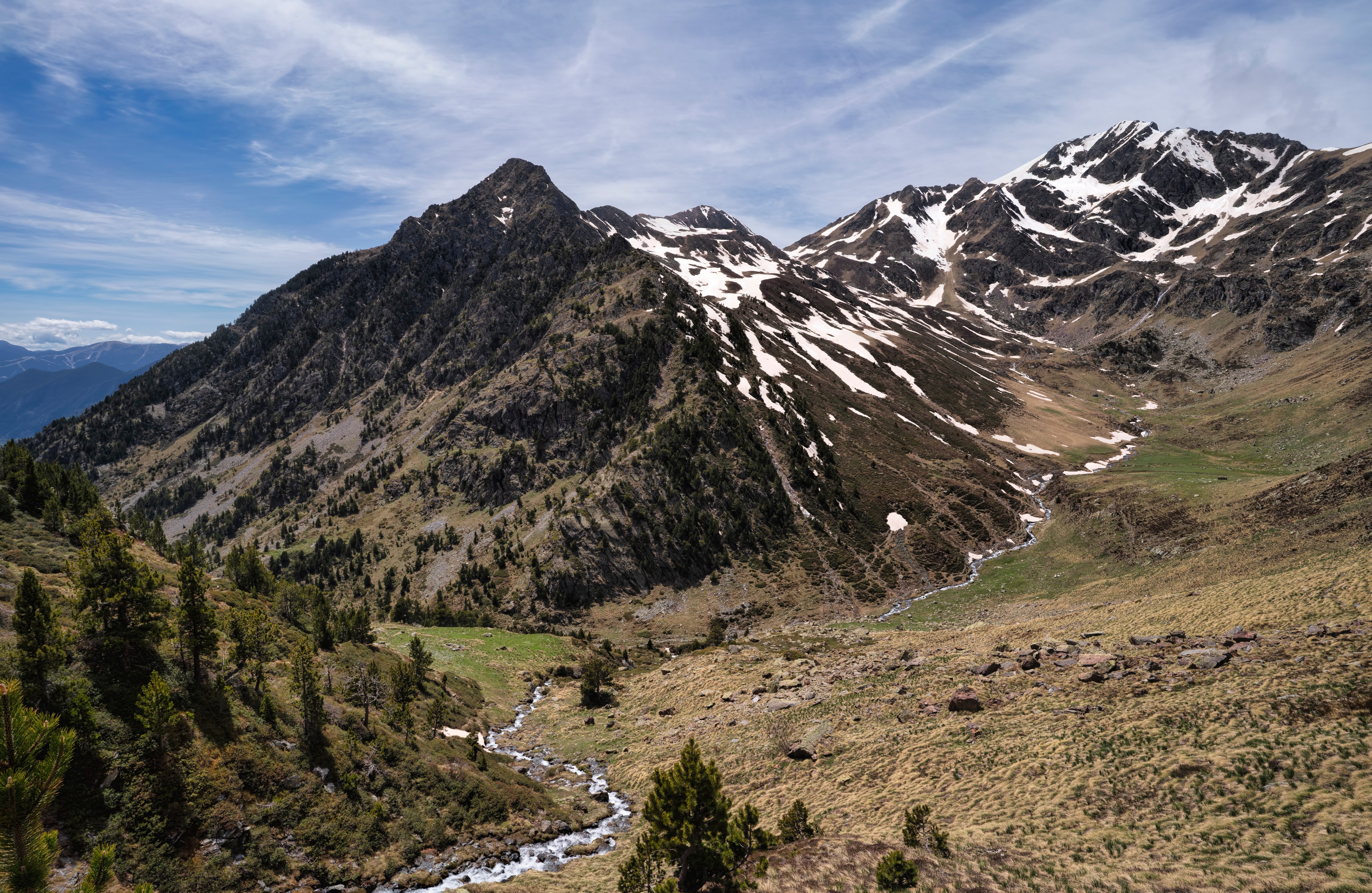 Mountain landscape with snow patches and a stream in Andorra HD Wallpaper