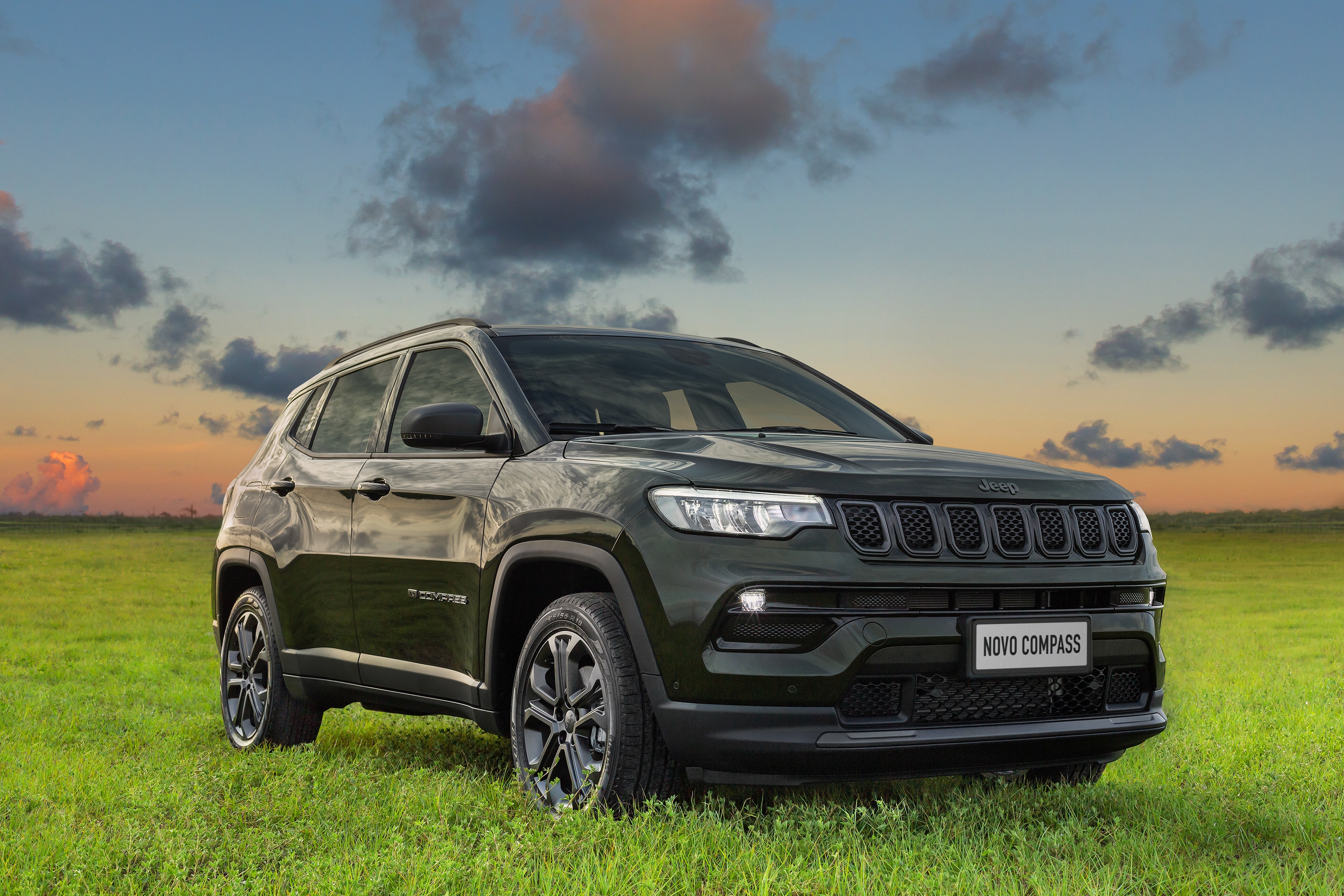 Jeep Compass Crossover in a grassy field at sunset HD Wallpaper