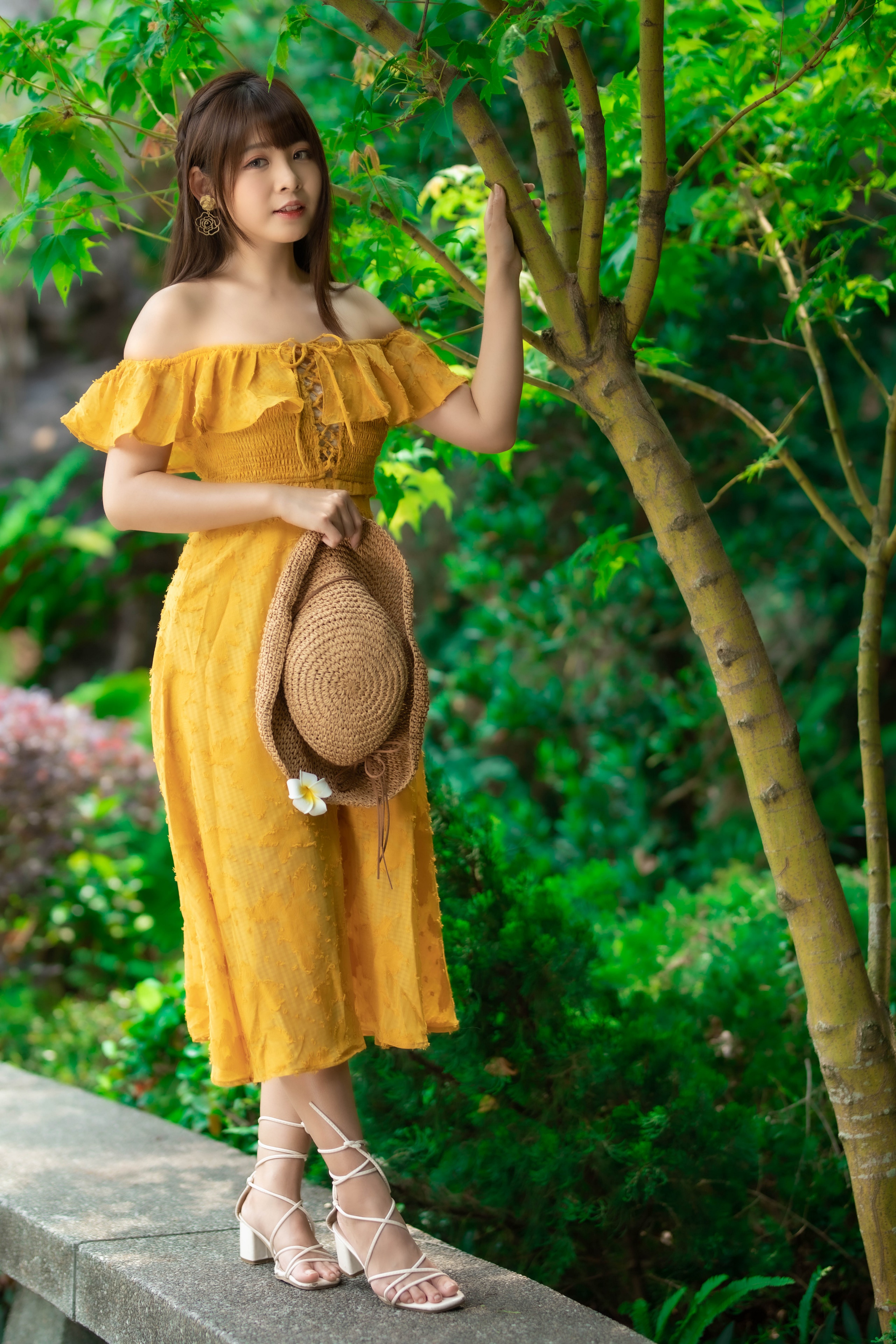Asian woman in yellow dress holding a hat HD Phone Wallpaper