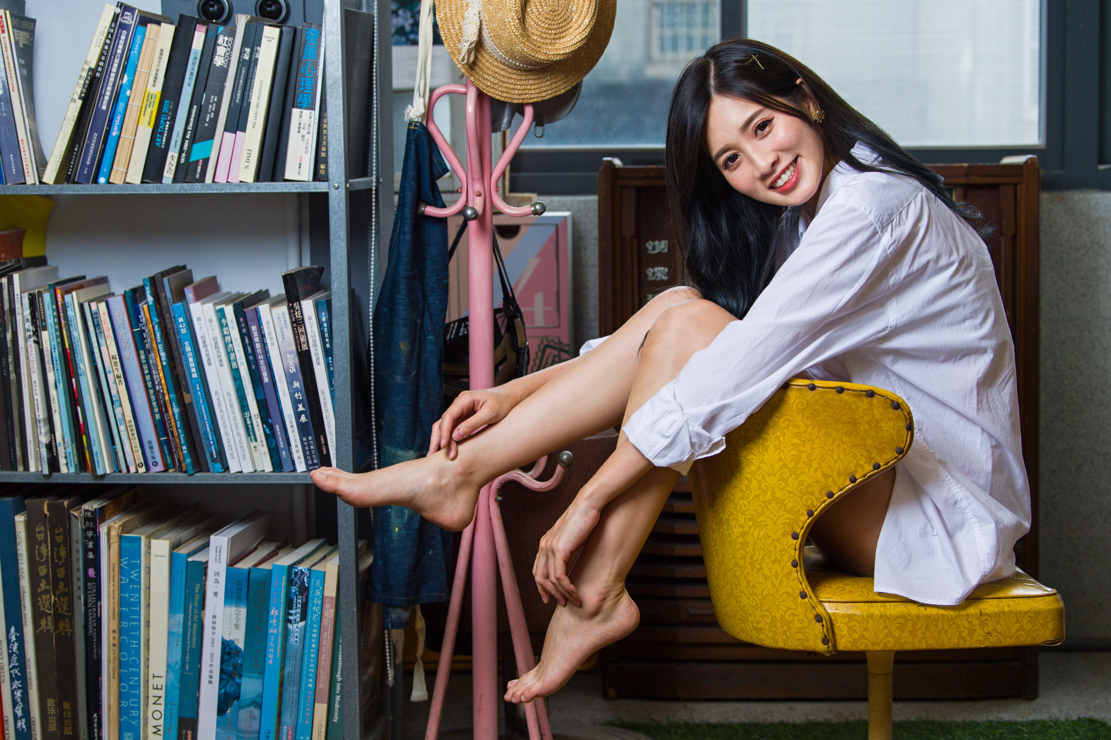 Brunette girl in formal shirt smiling, sitting on a chair HD Wallpaper