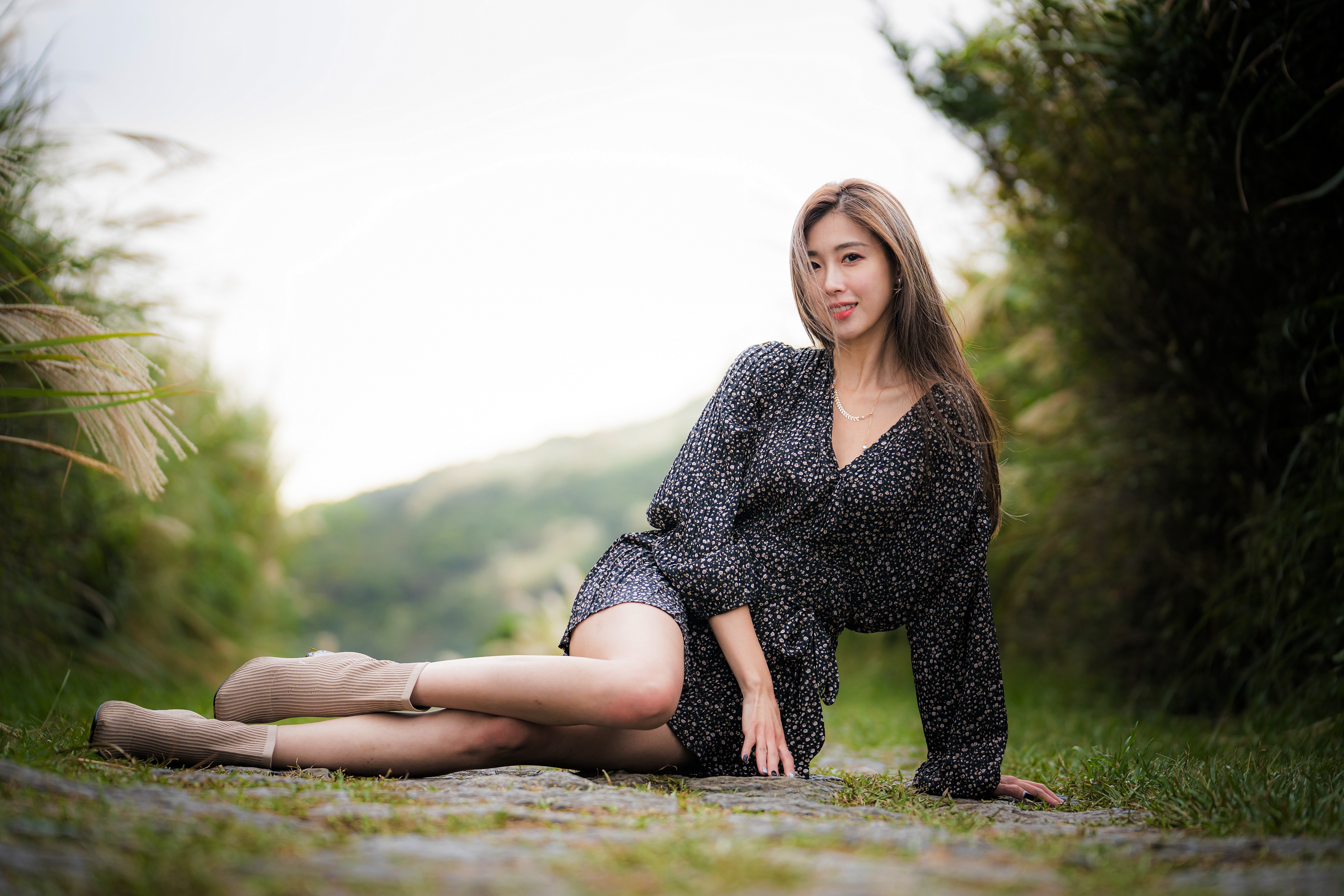 Asian woman in dress sitting on path HD Wallpaper