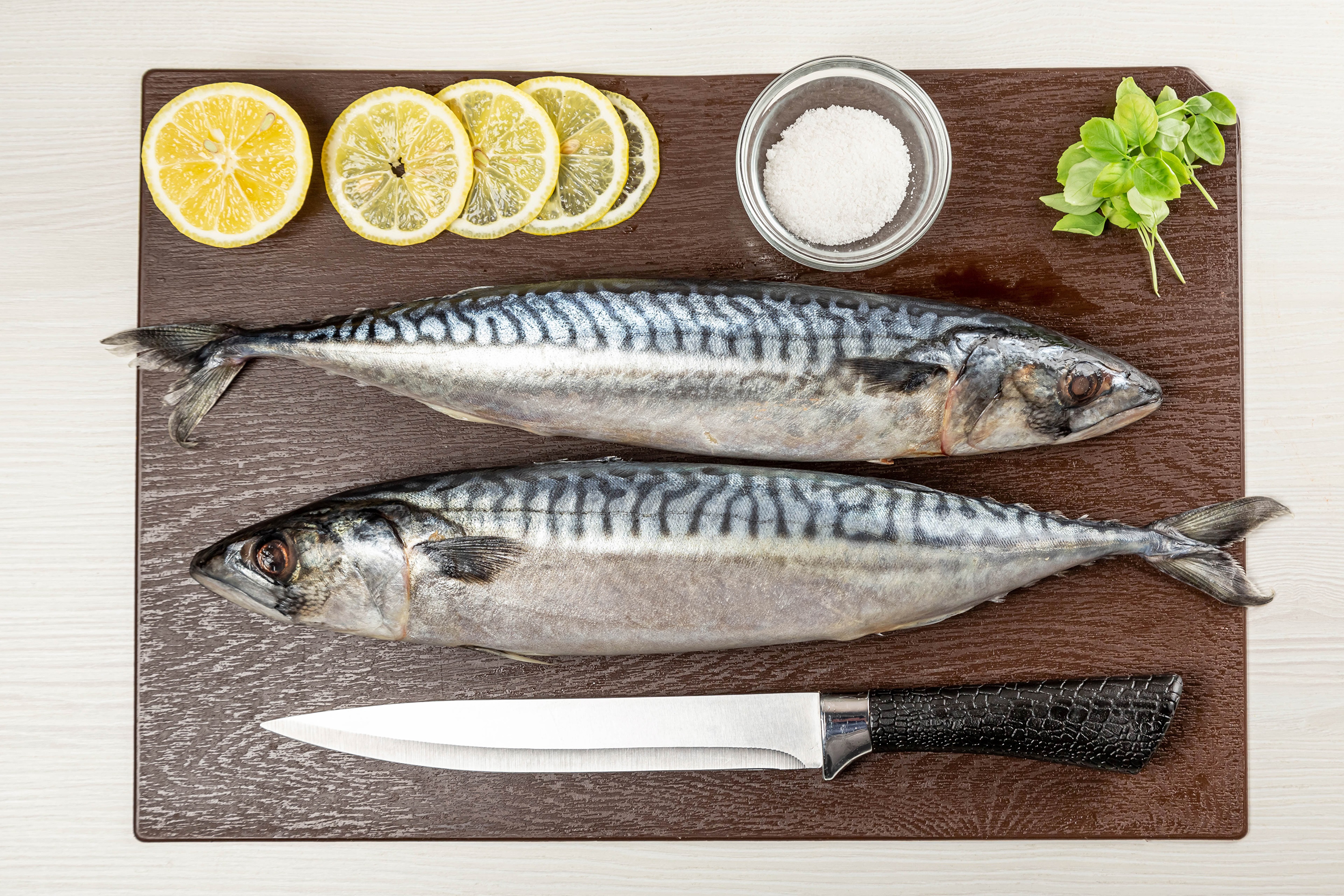 Two Mackerel Fish with Lemons, Salt, and Knife on Cutting Board HD Wallpaper