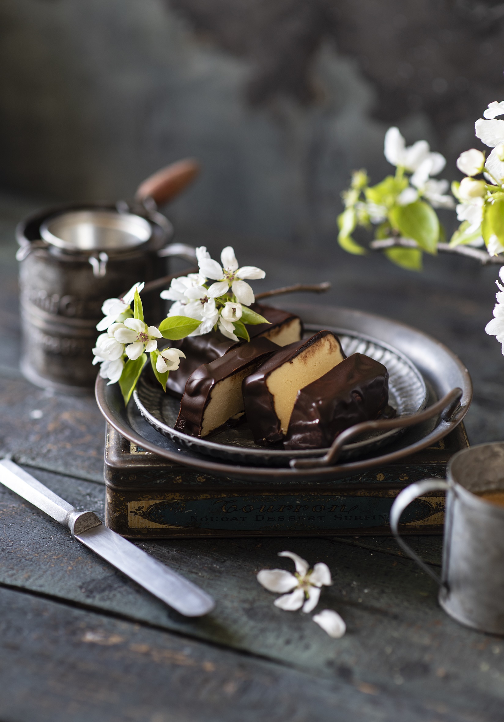 Chocolate-covered dessert with white flowers and vintage tin HD Phone Wallpaper
