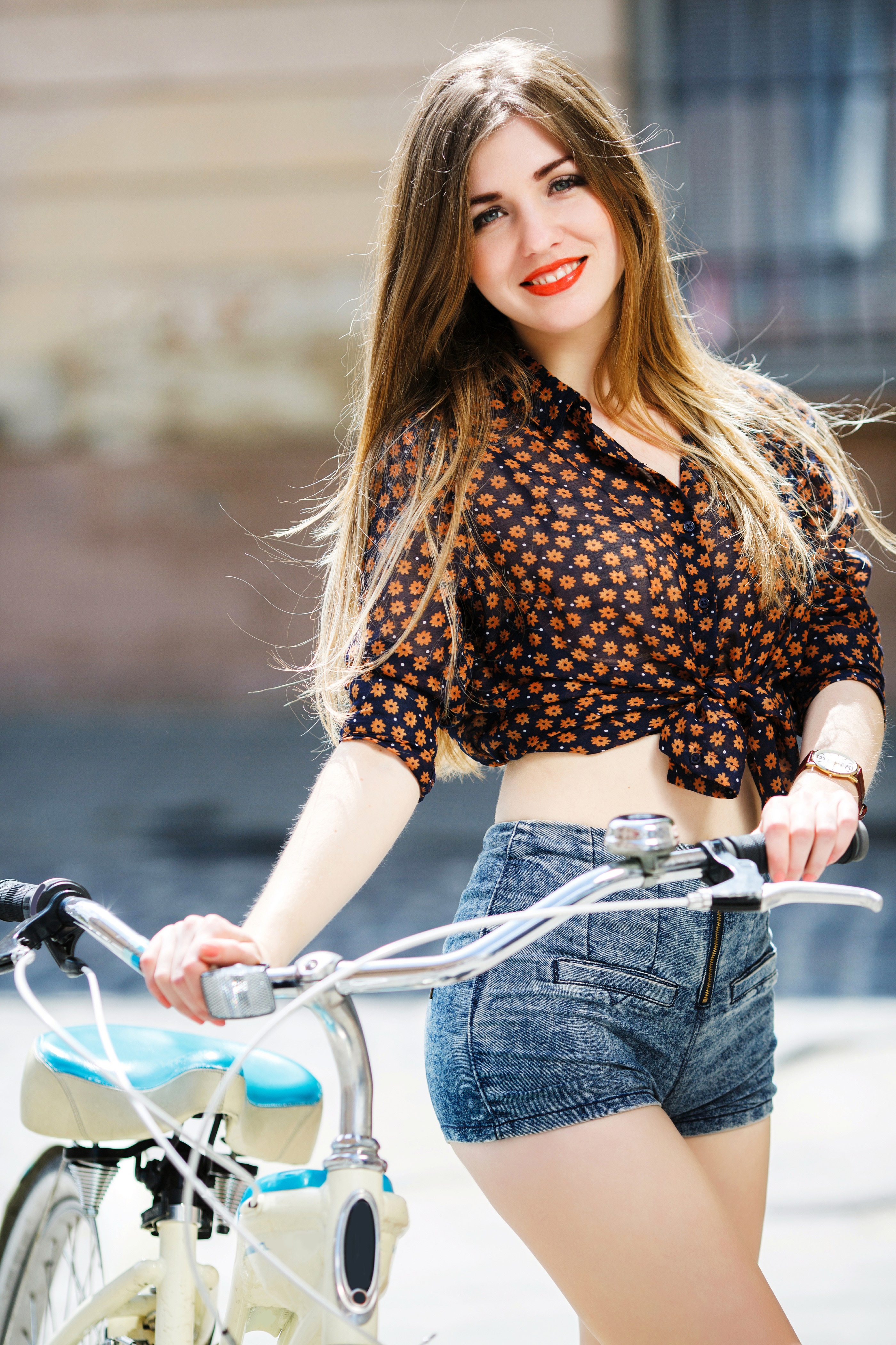 Woman with brown hair and red lips posing with a bicycle HD Phone Wallpaper