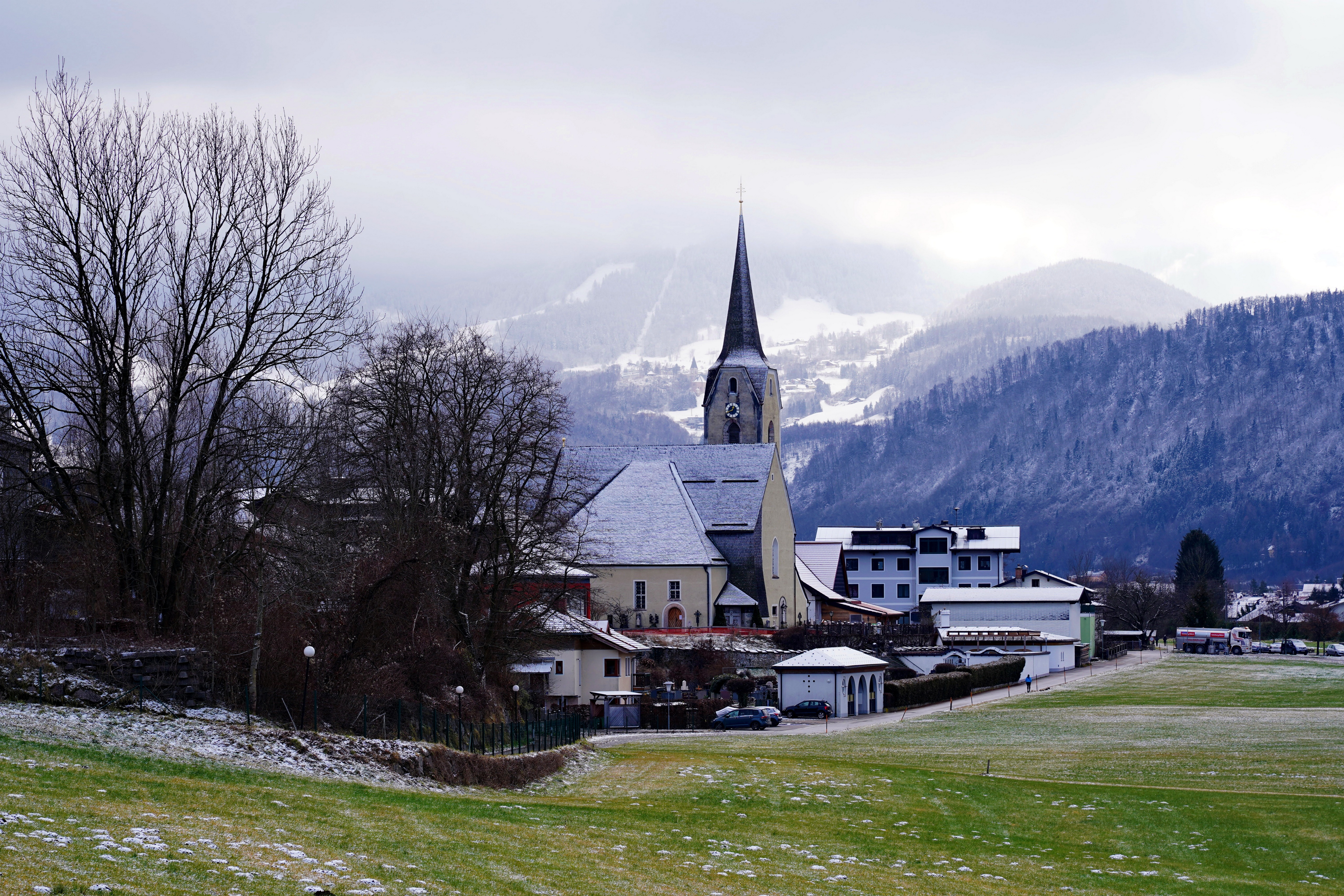 Church and houses in Puch bei Hellein, Austria with Alps mountains HD Wallpaper