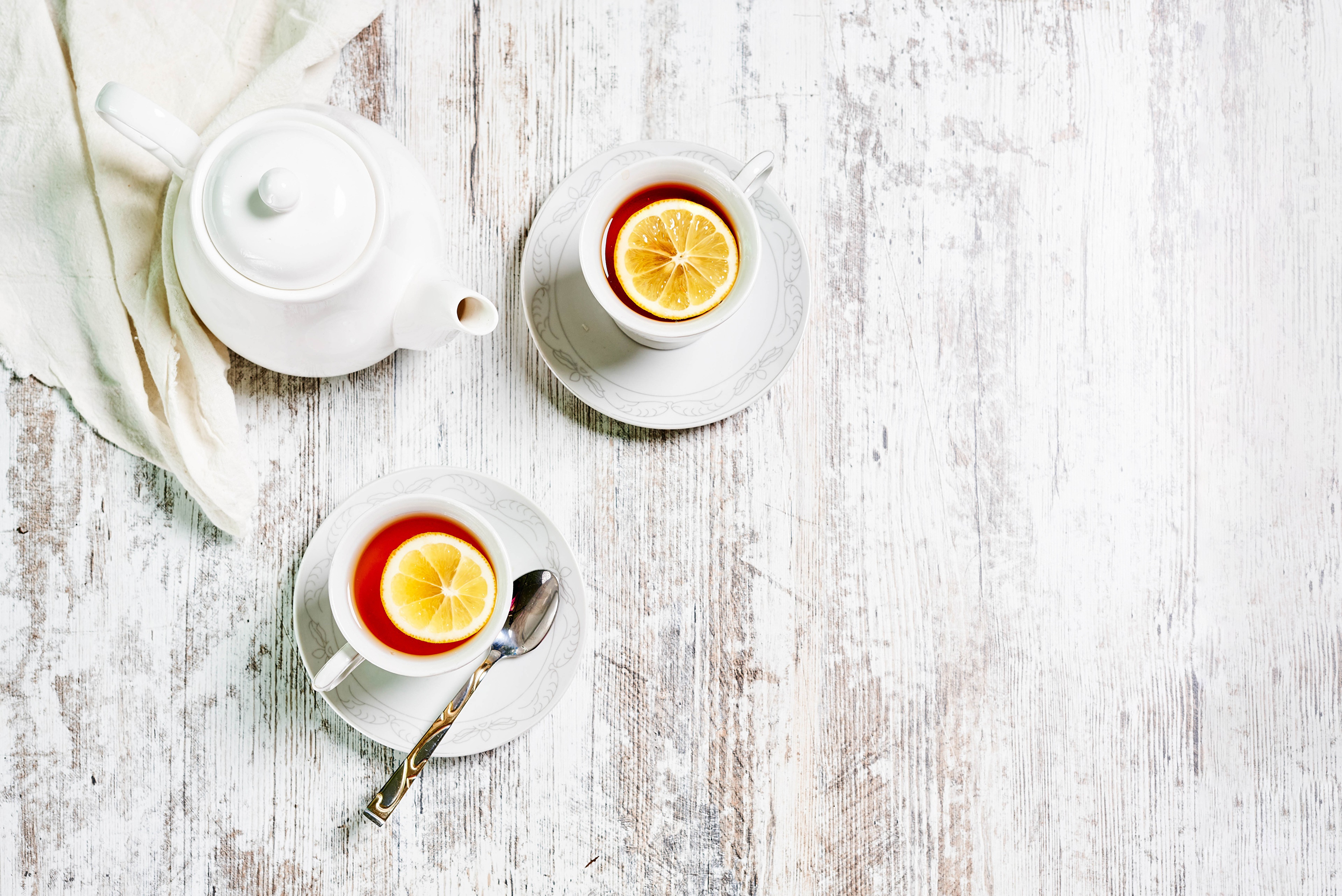 Tea with lemon and teapot on wooden table HD Wallpaper