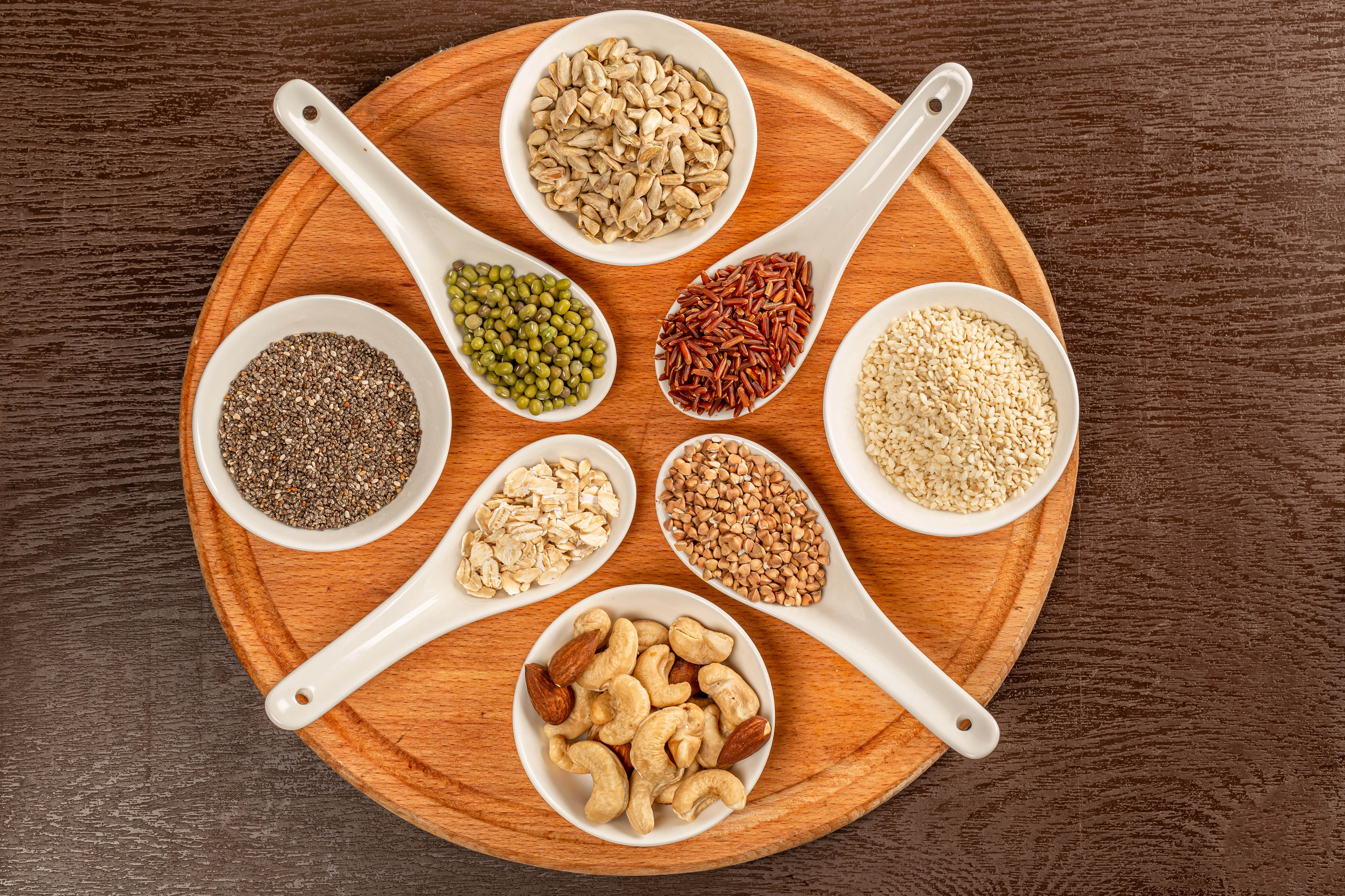 Assortment of Grains, Seeds, and Nuts on Cutting Board HD Wallpaper