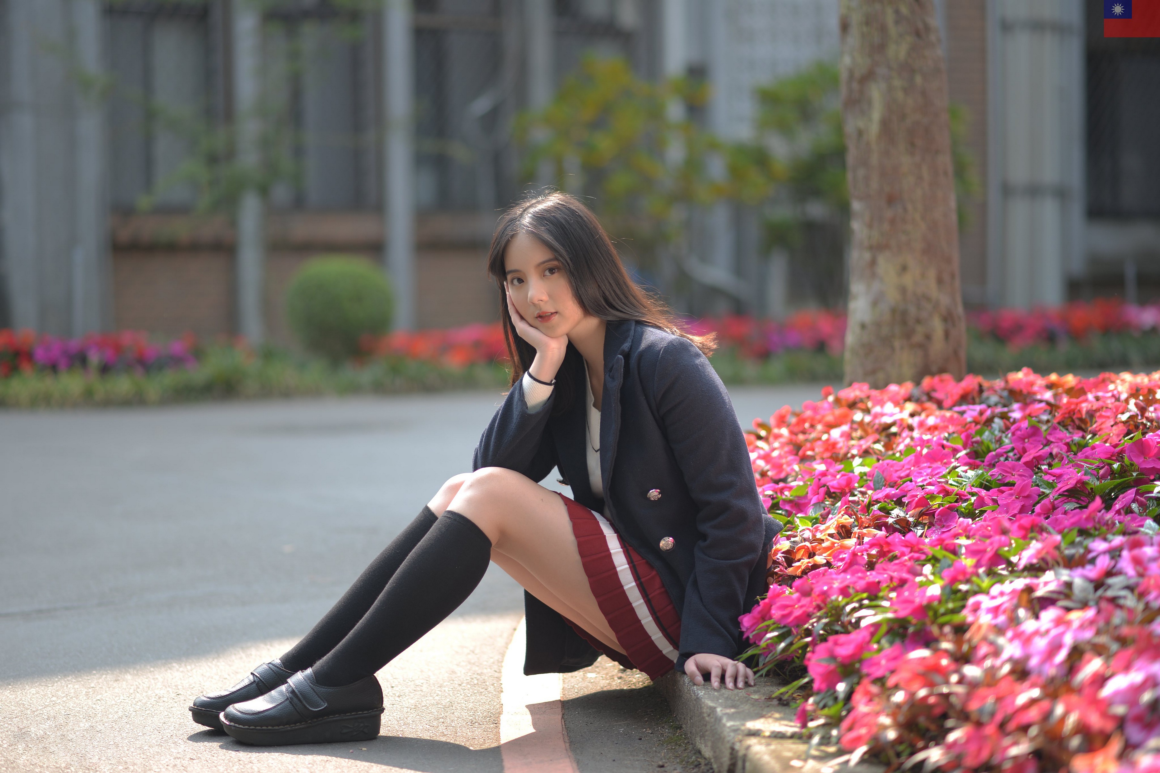 Asian girl in school uniform sitting by flowers HD Wallpaper