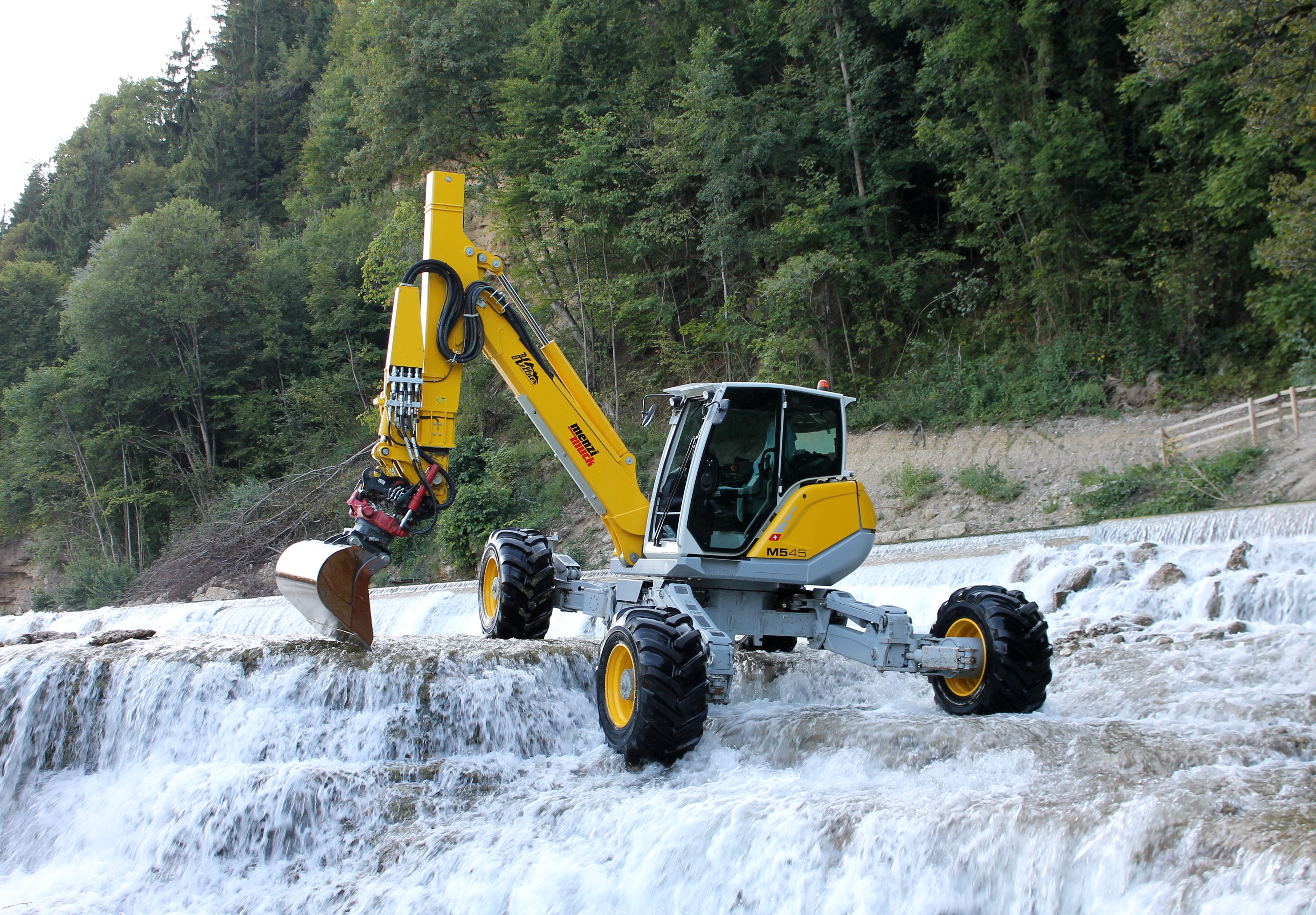 Menzi Muck M545 excavator on a waterfall HD Wallpaper