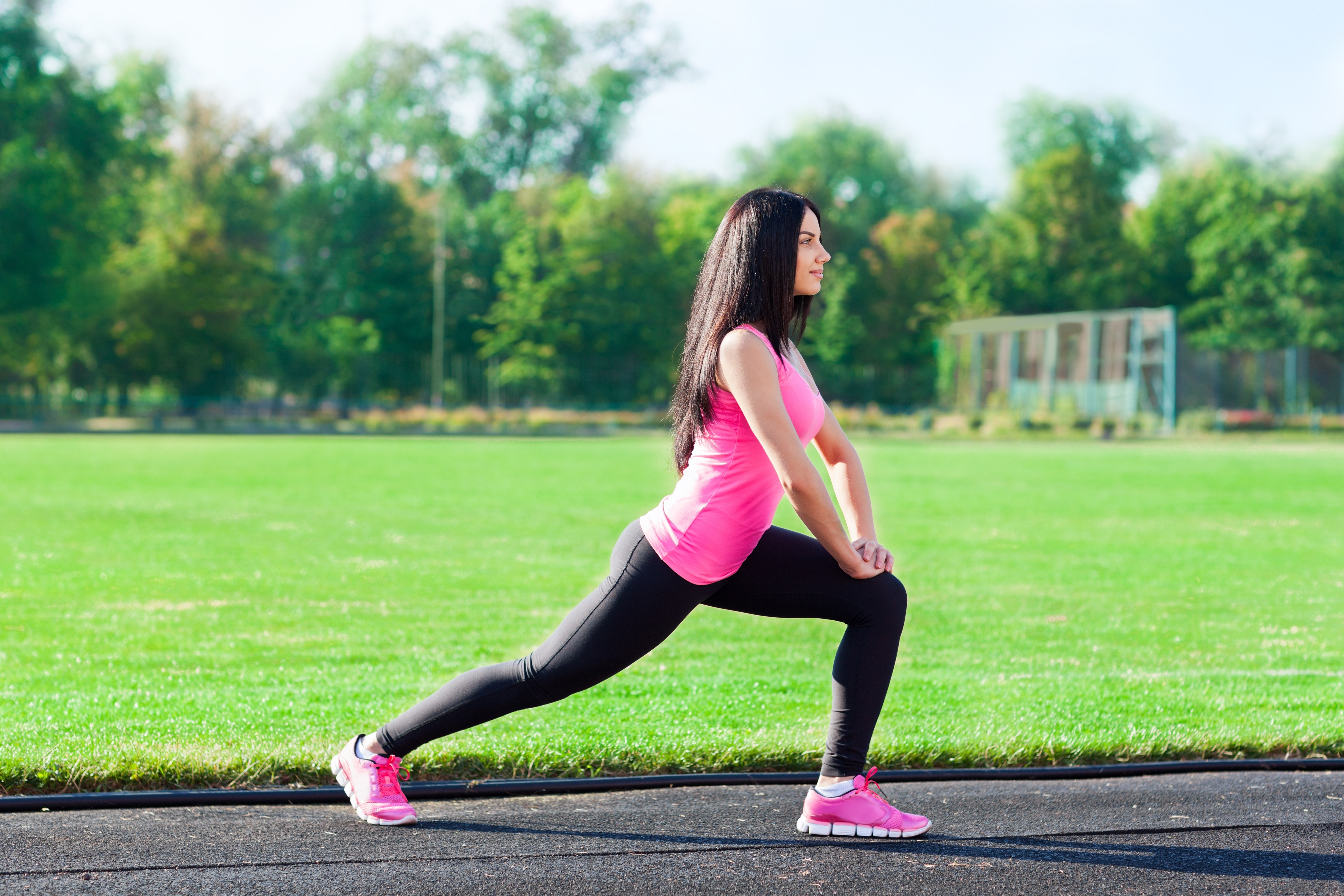 Brunette girl doing a stretch exercise outdoors HD Wallpaper