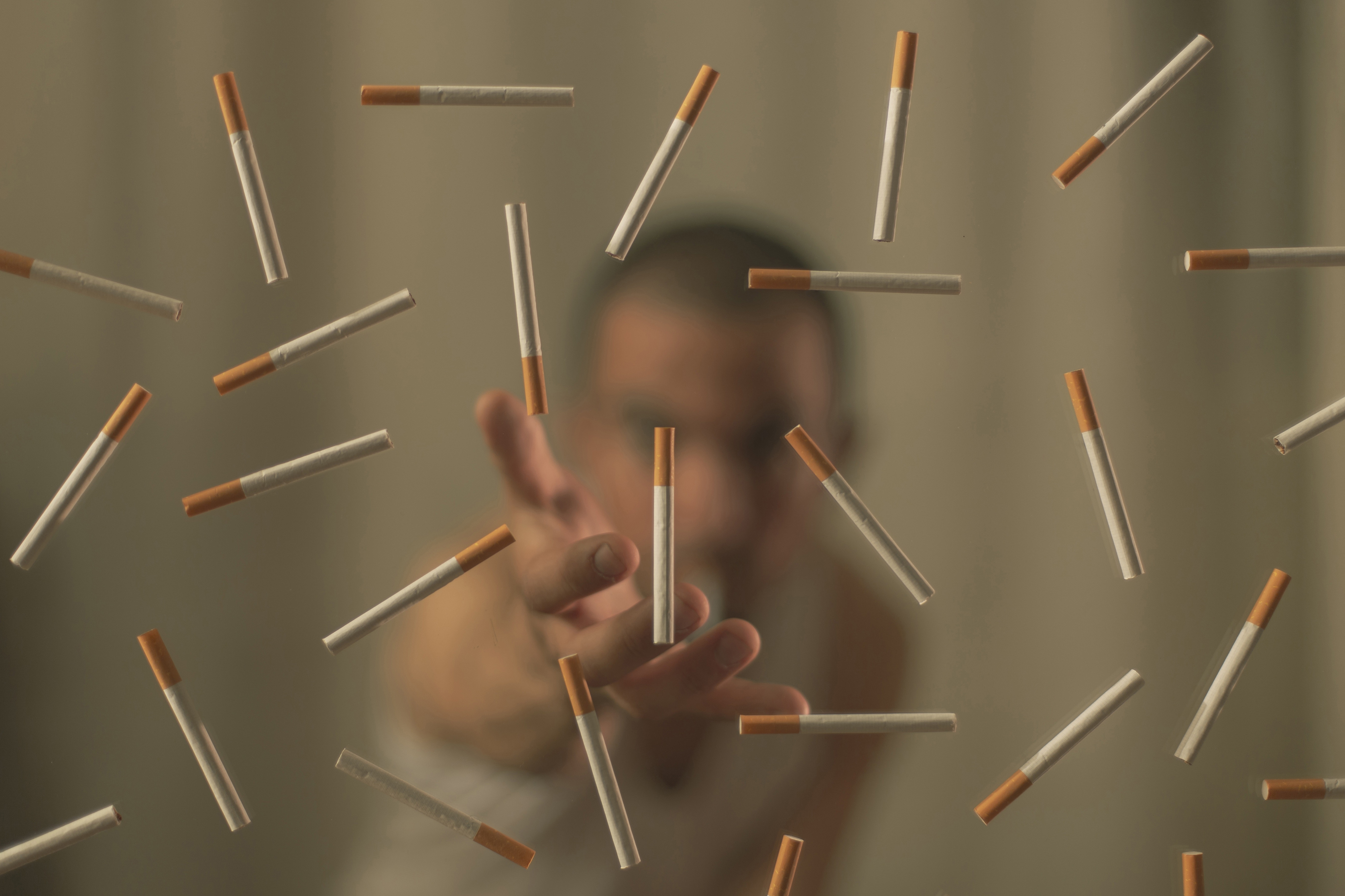 Man reaching for falling cigarettes HD Wallpaper