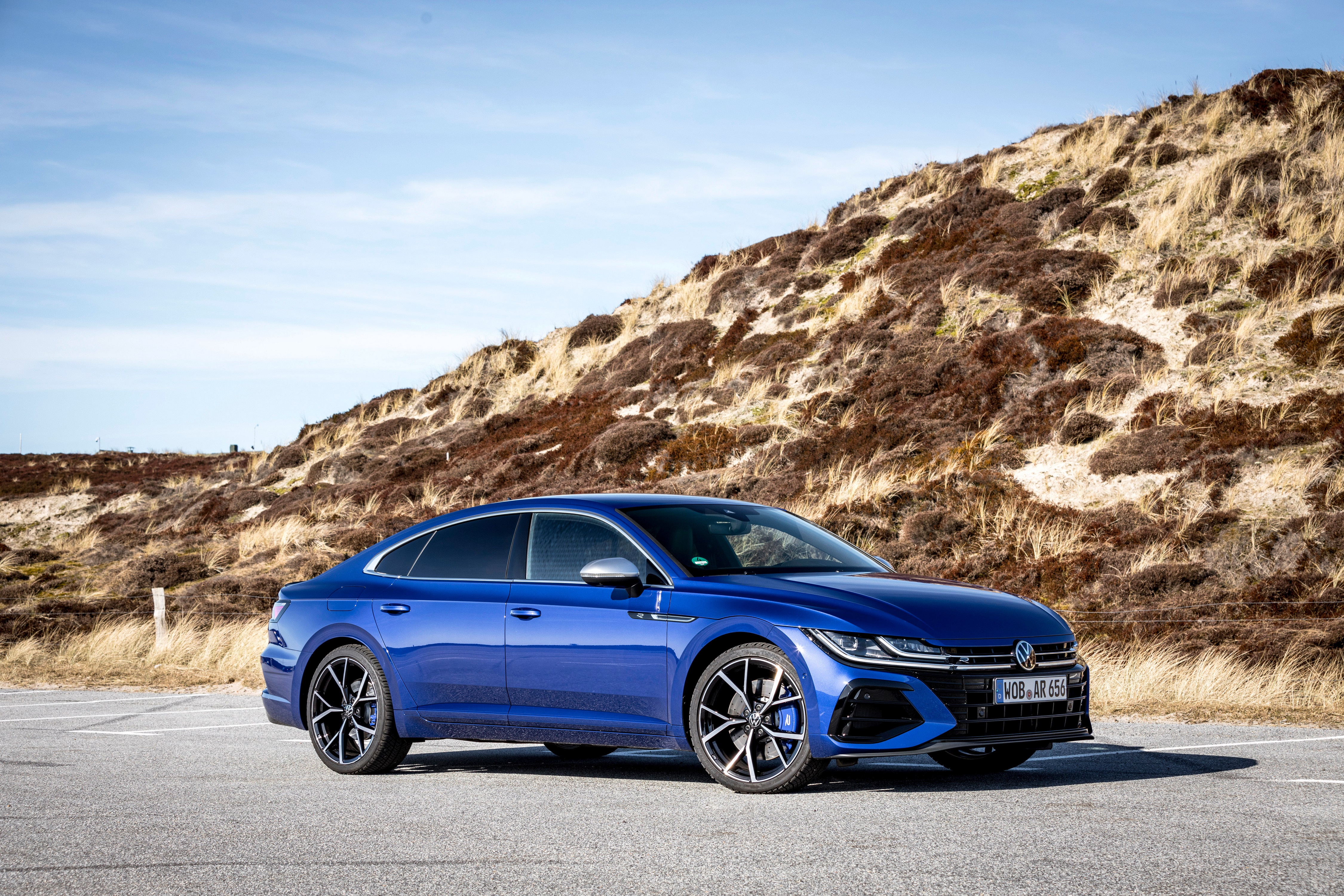Blue Volkswagen Arteon R parked near a sandy hill HD Wallpaper