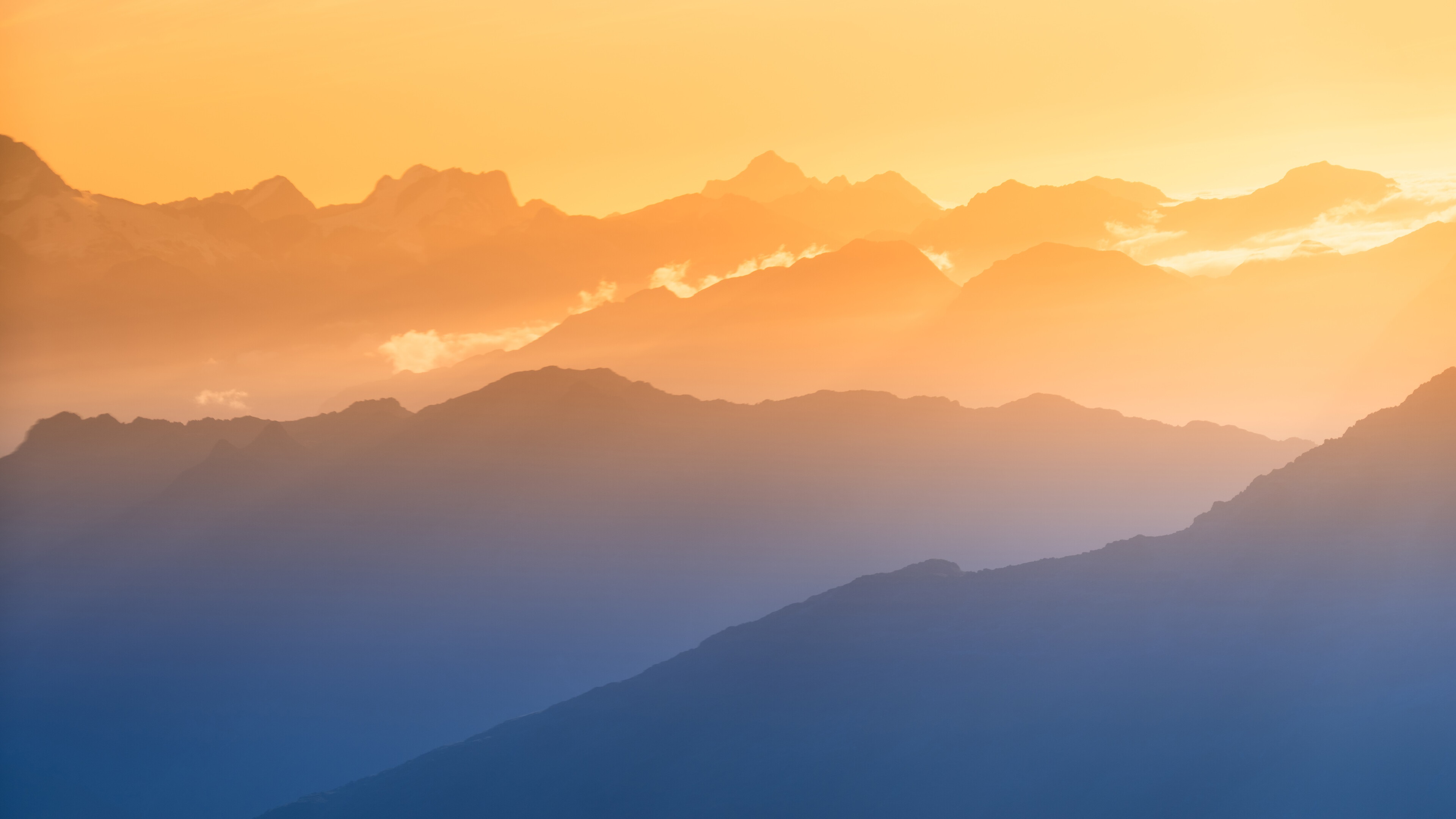 Mountain range at sunset with orange sky HD Wallpaper