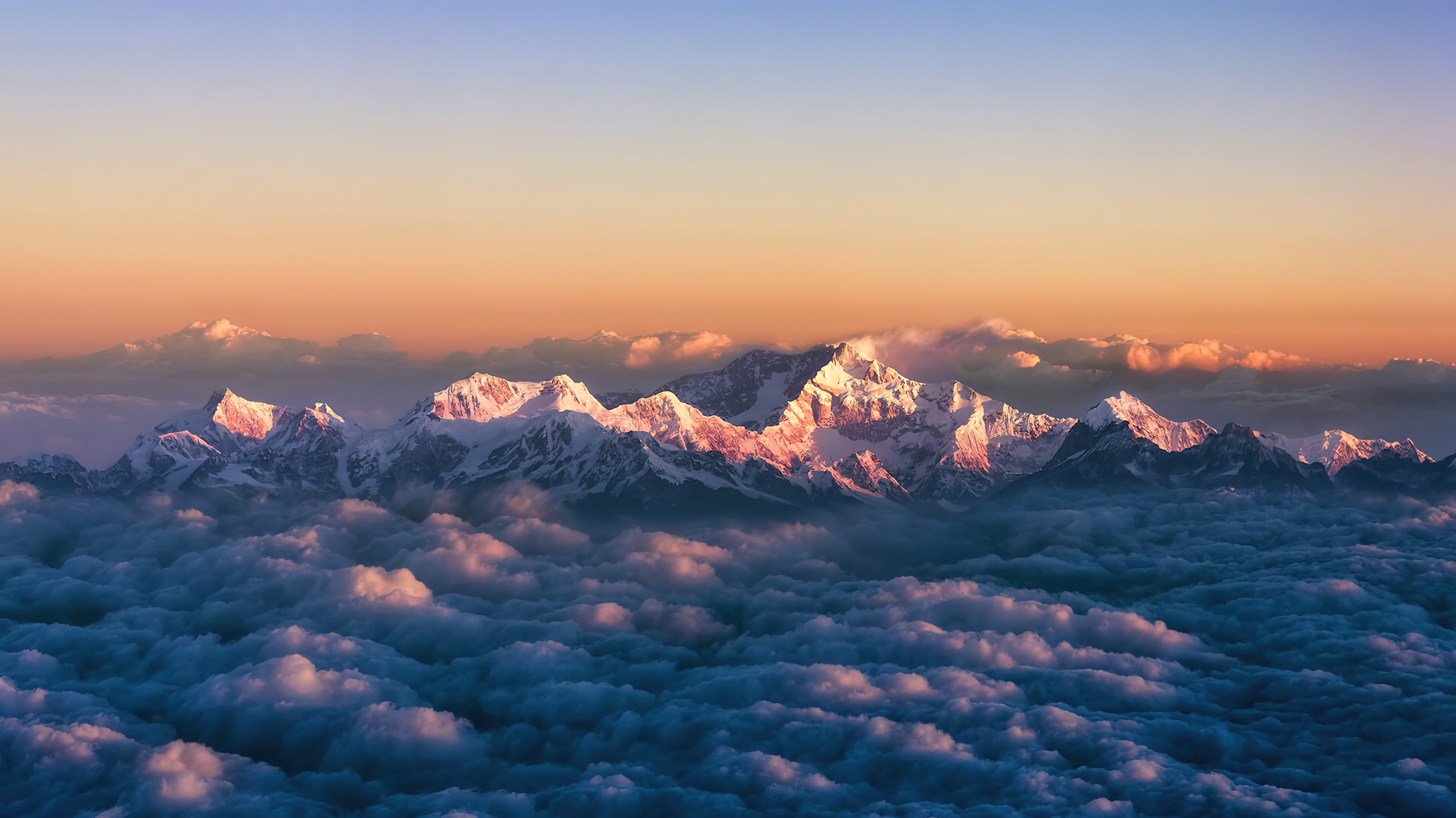 Sunrise over snow-capped mountains above clouds in 4K HD Wallpaper