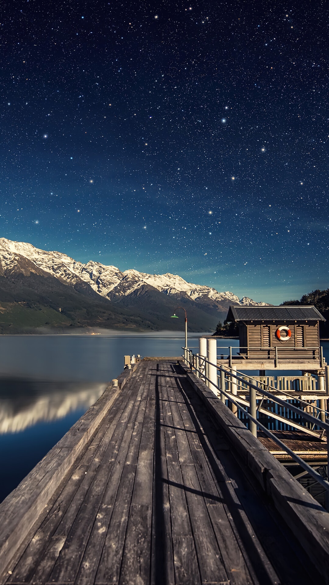 Wooden pier under starry sky with snow-capped mountains HD Phone Wallpaper